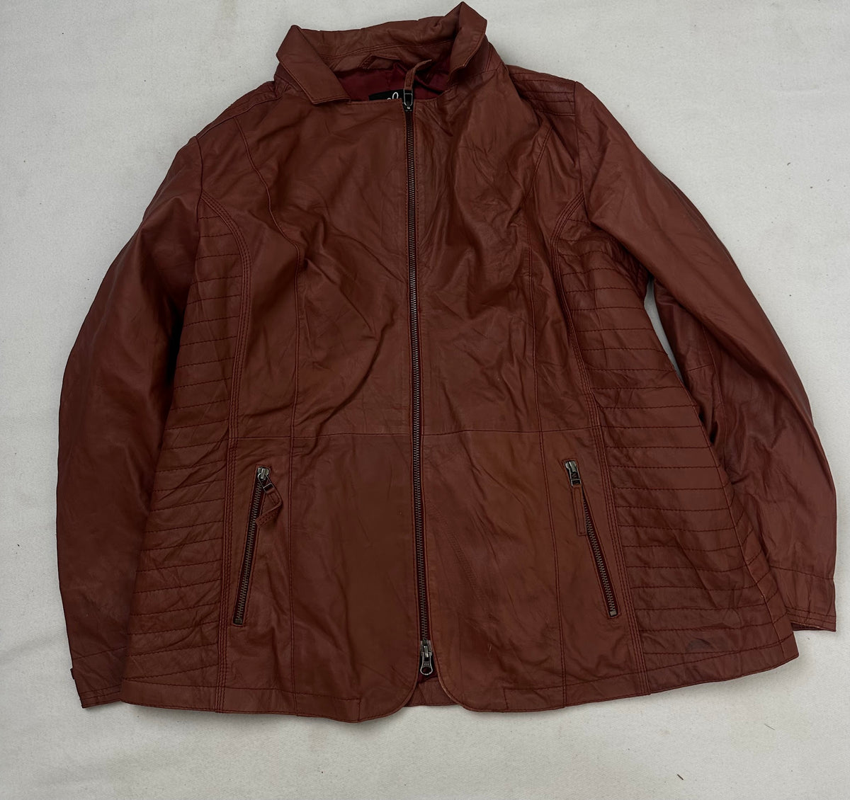 Front of the size XL burgundy leather vintage jacket, laid flat and unedited