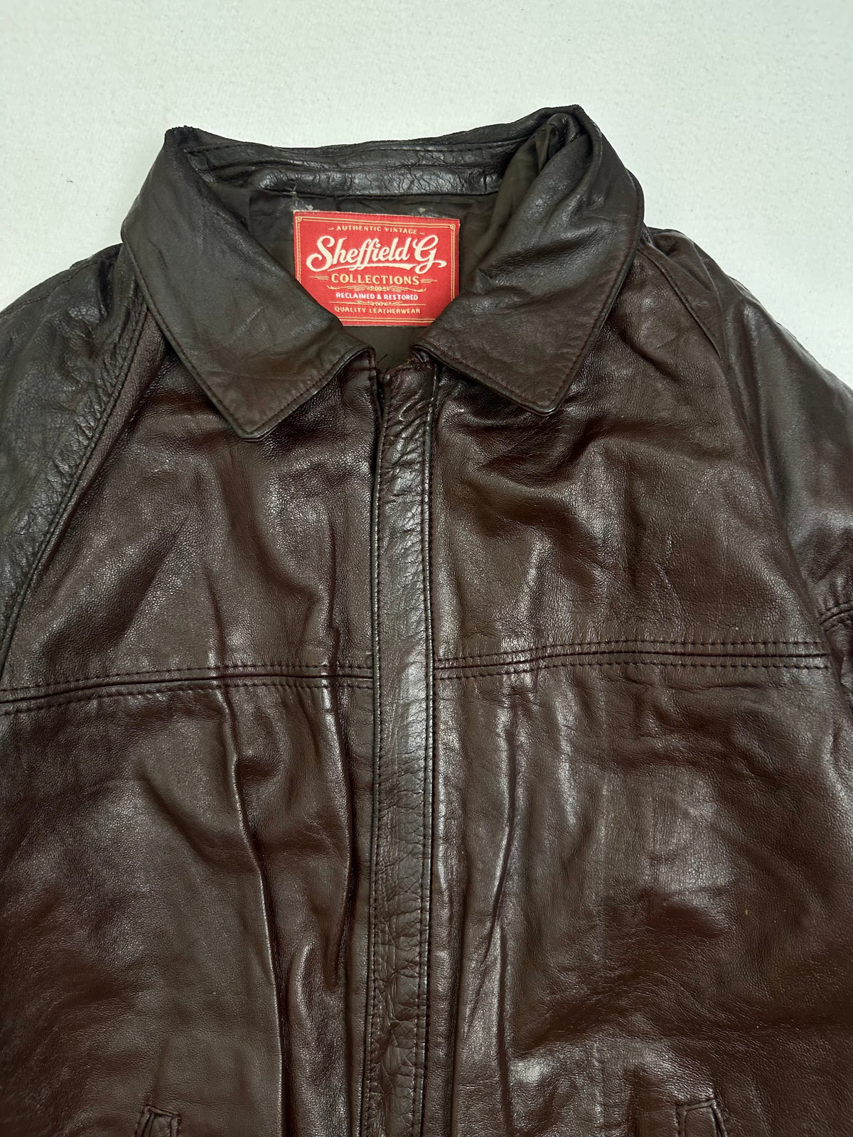 Collar and zip of the size M burgundy leather harrington jacket, up close