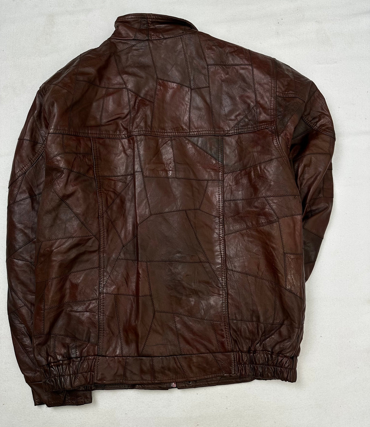 Back of the size XL burgundy leather flight jacket, laid flat
