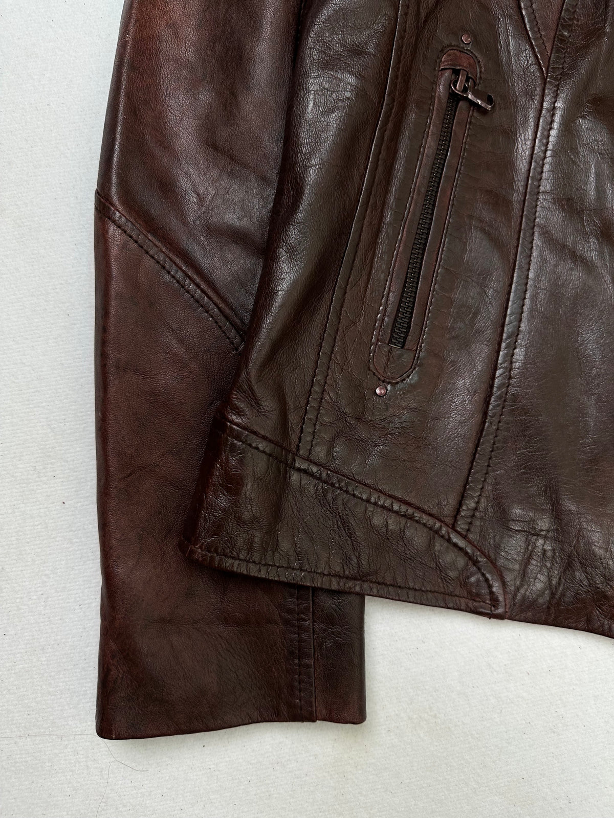 Close detail of the pockets and cuff on the size S burgundy leather vintage jacket