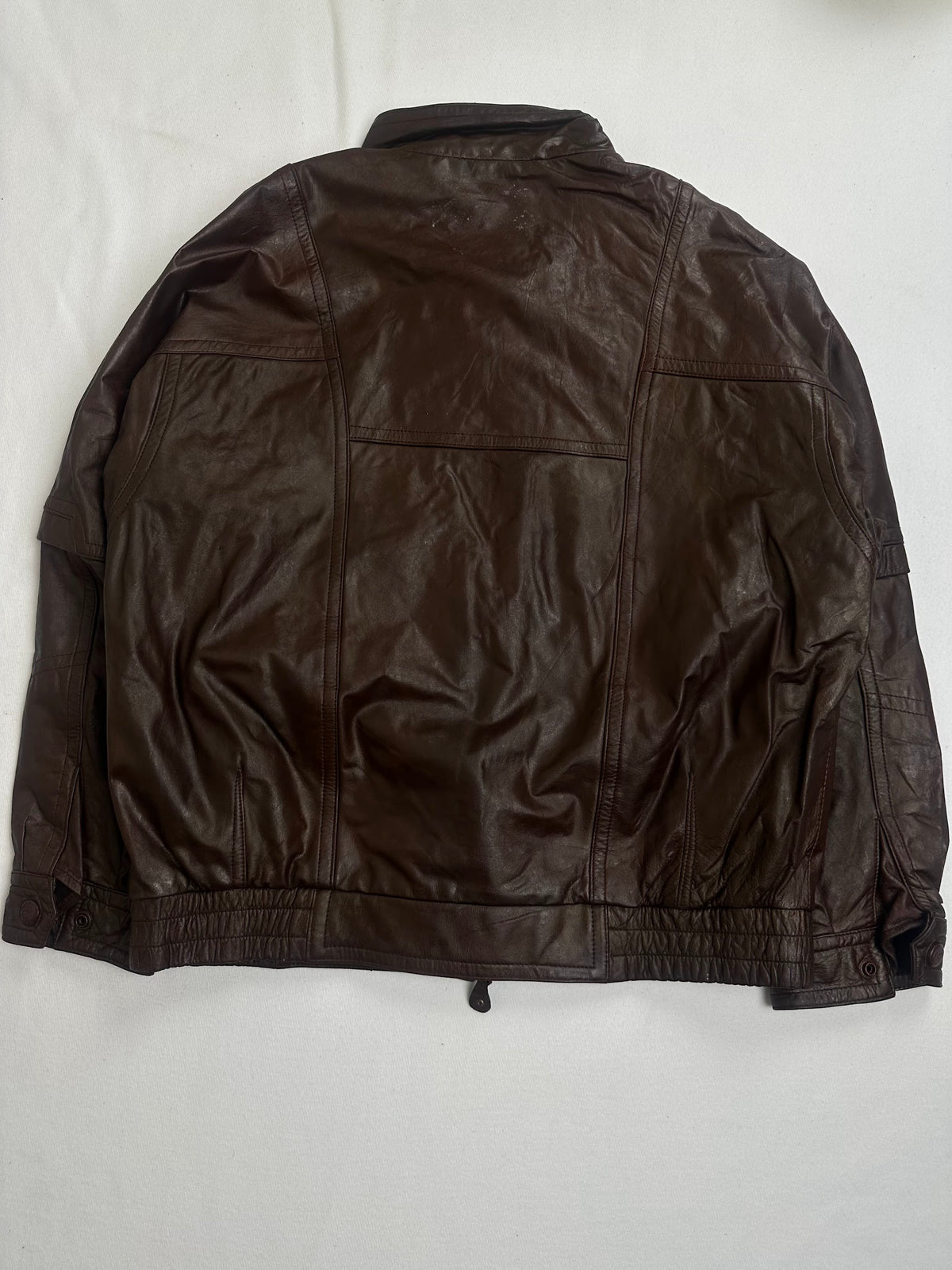 Stand collar closed by its two button throat tab on the brown jacket