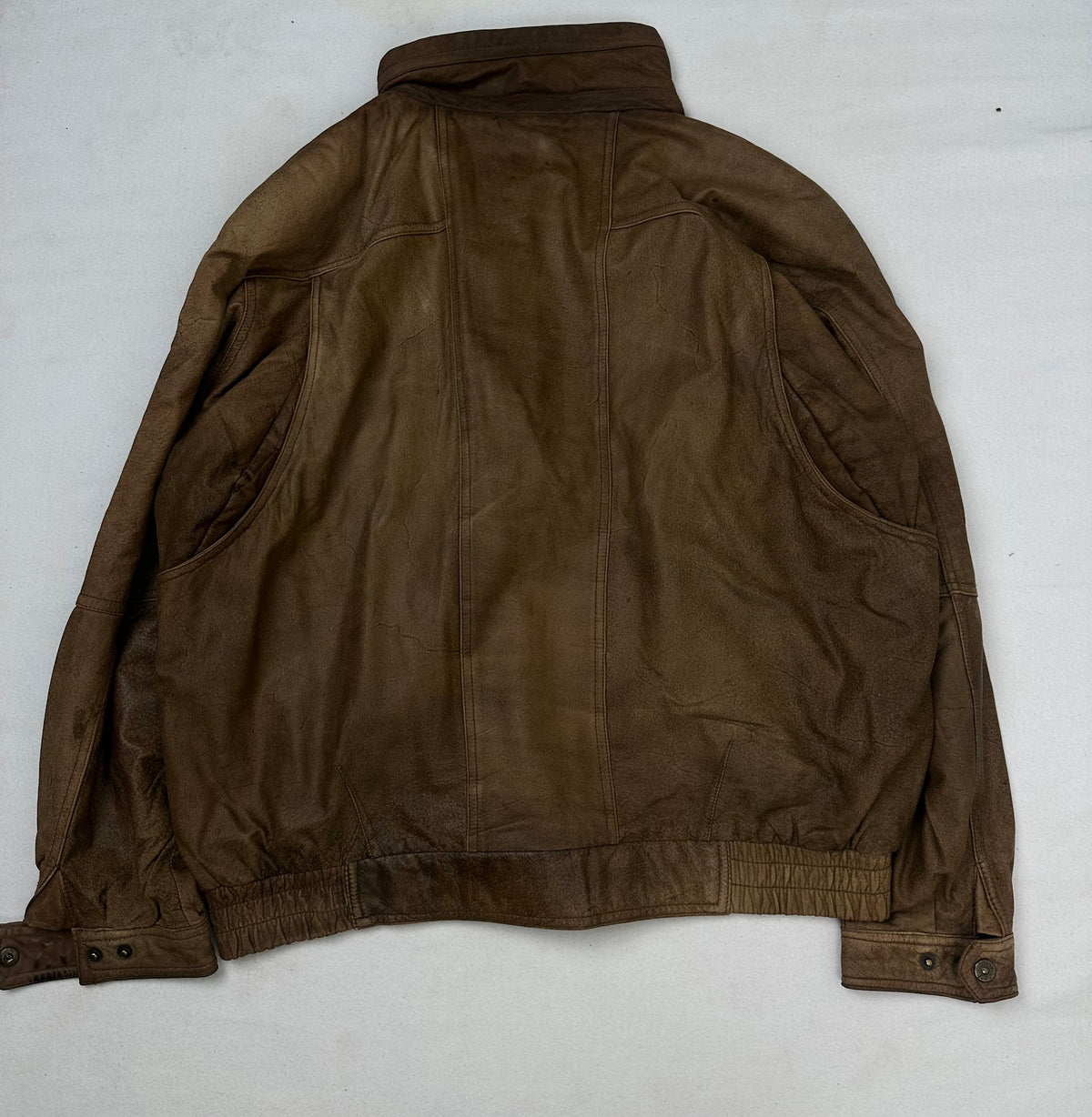Back of the size XL brown leather flight jacket, laid flat