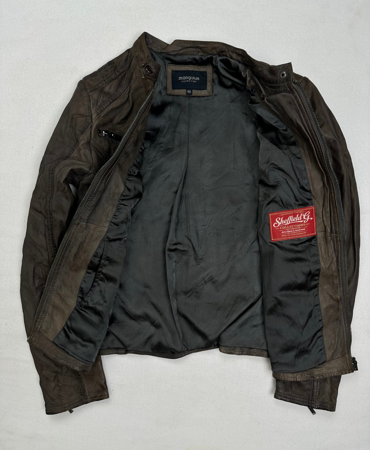 The size S brown leather cafe racer jacket opened to show the lining
