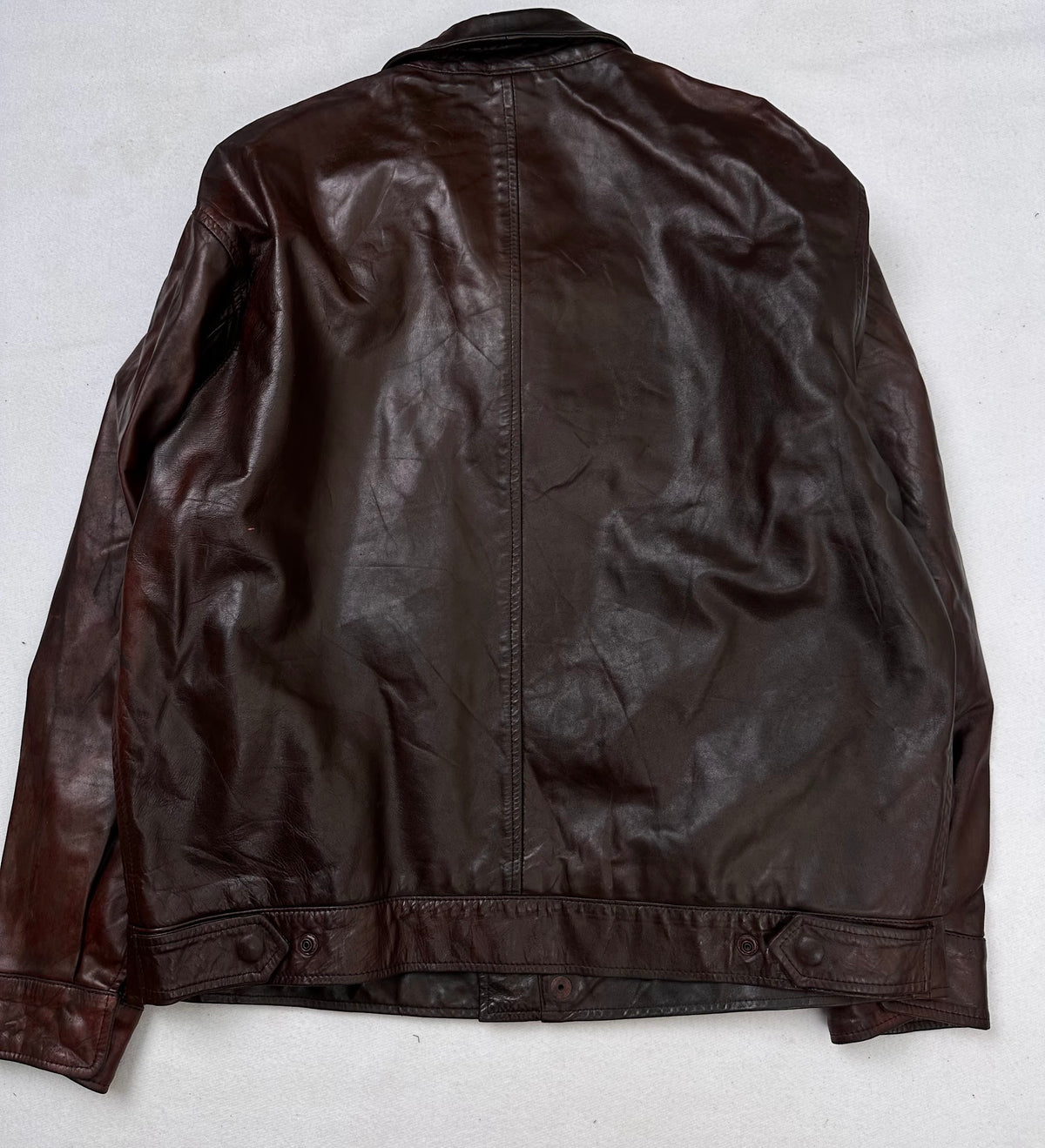 Back of the size S burgundy leather vintage jacket, laid flat