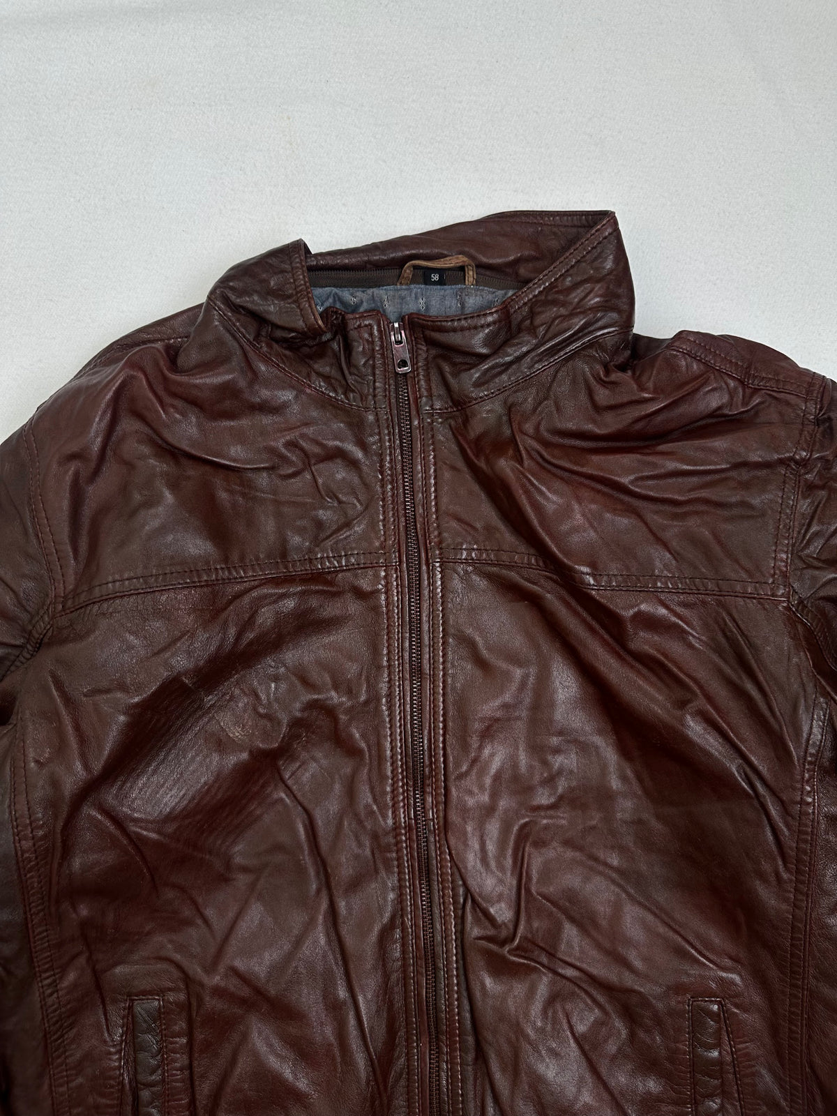 Collar and zip of the size XL burgundy leather bomber jacket, up close