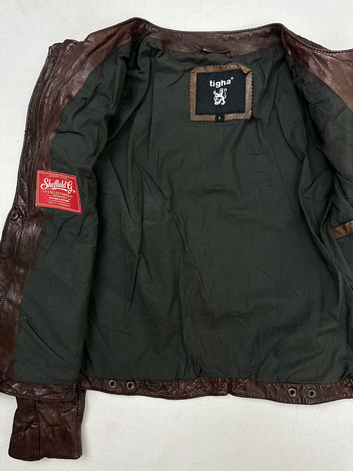 The size S burgundy leather vintage jacket opened to show the lining