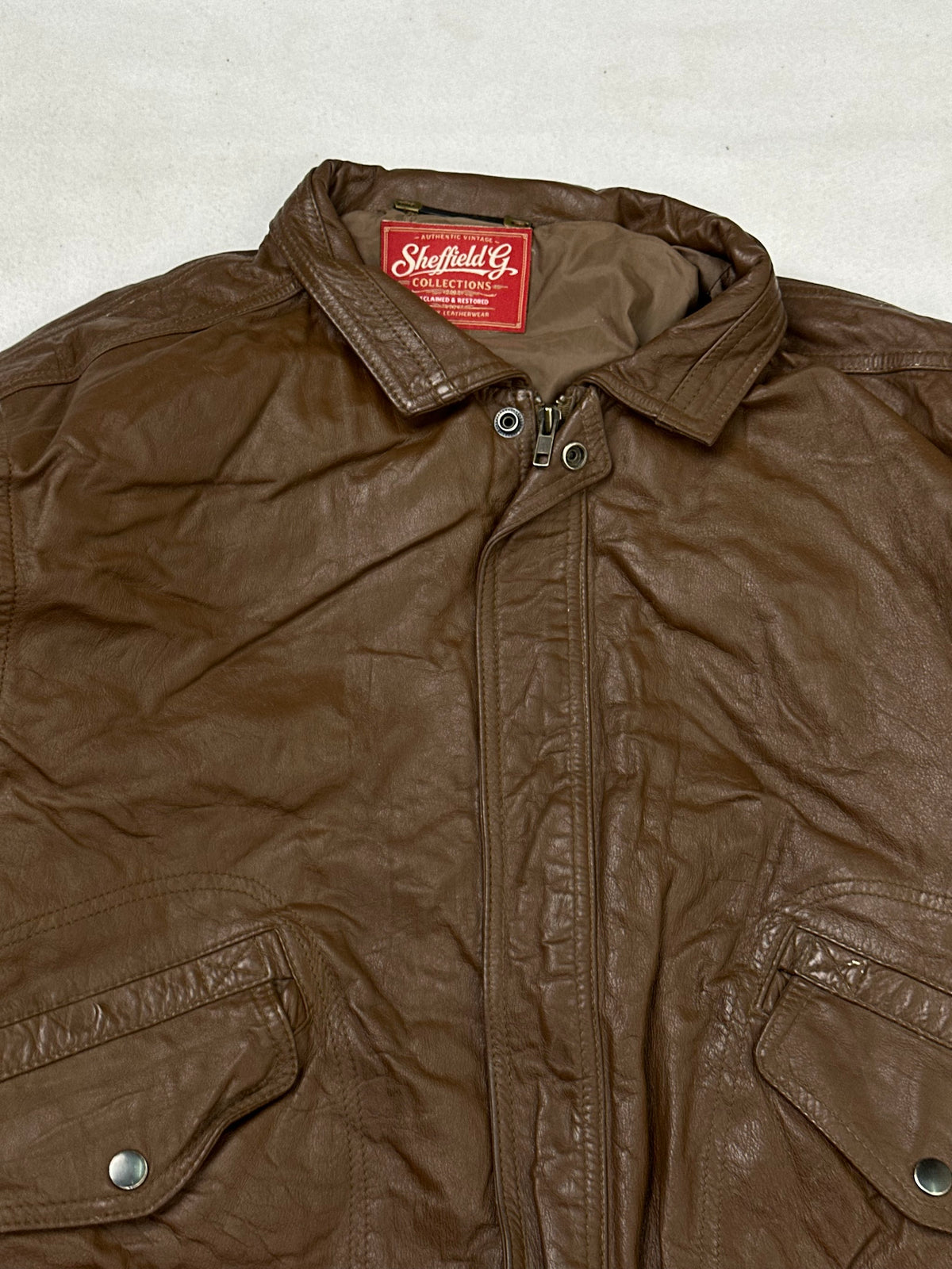Collar and zip of the size M brown leather flight jacket, up close