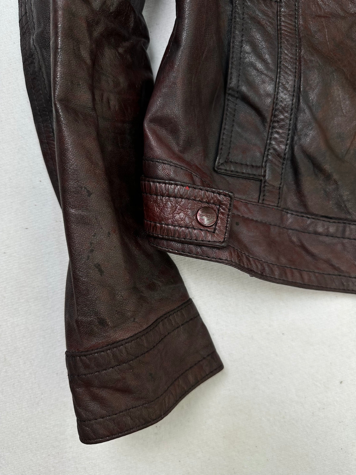 Close detail of the pockets and cuff on the size S burgundy leather cafe racer jacket