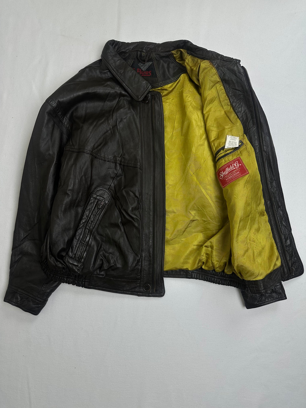 Horizontal welt pocket above a slanted zip hand pocket on the brown jacket
