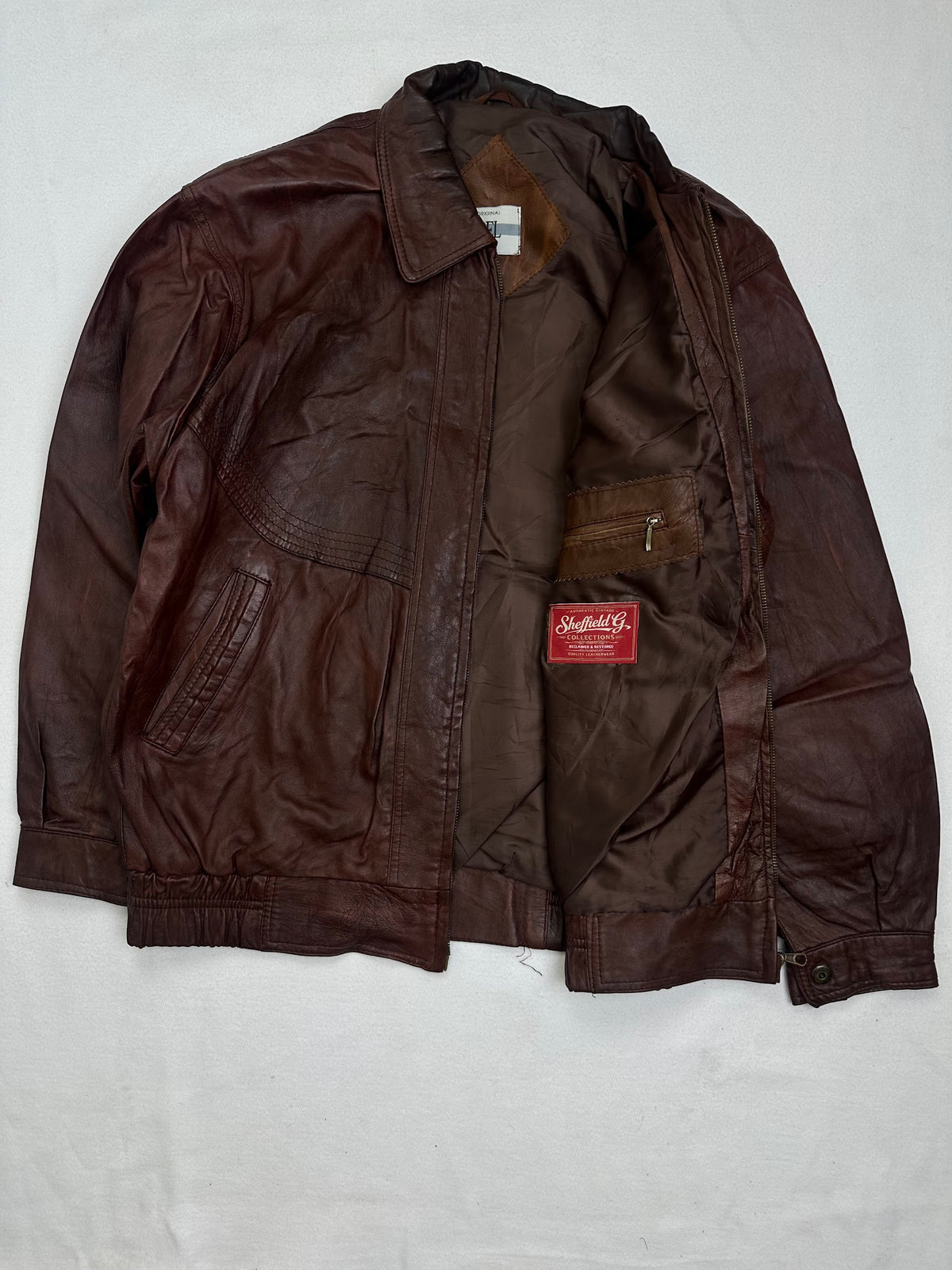 The size XL burgundy leather harrington jacket opened to show the lining