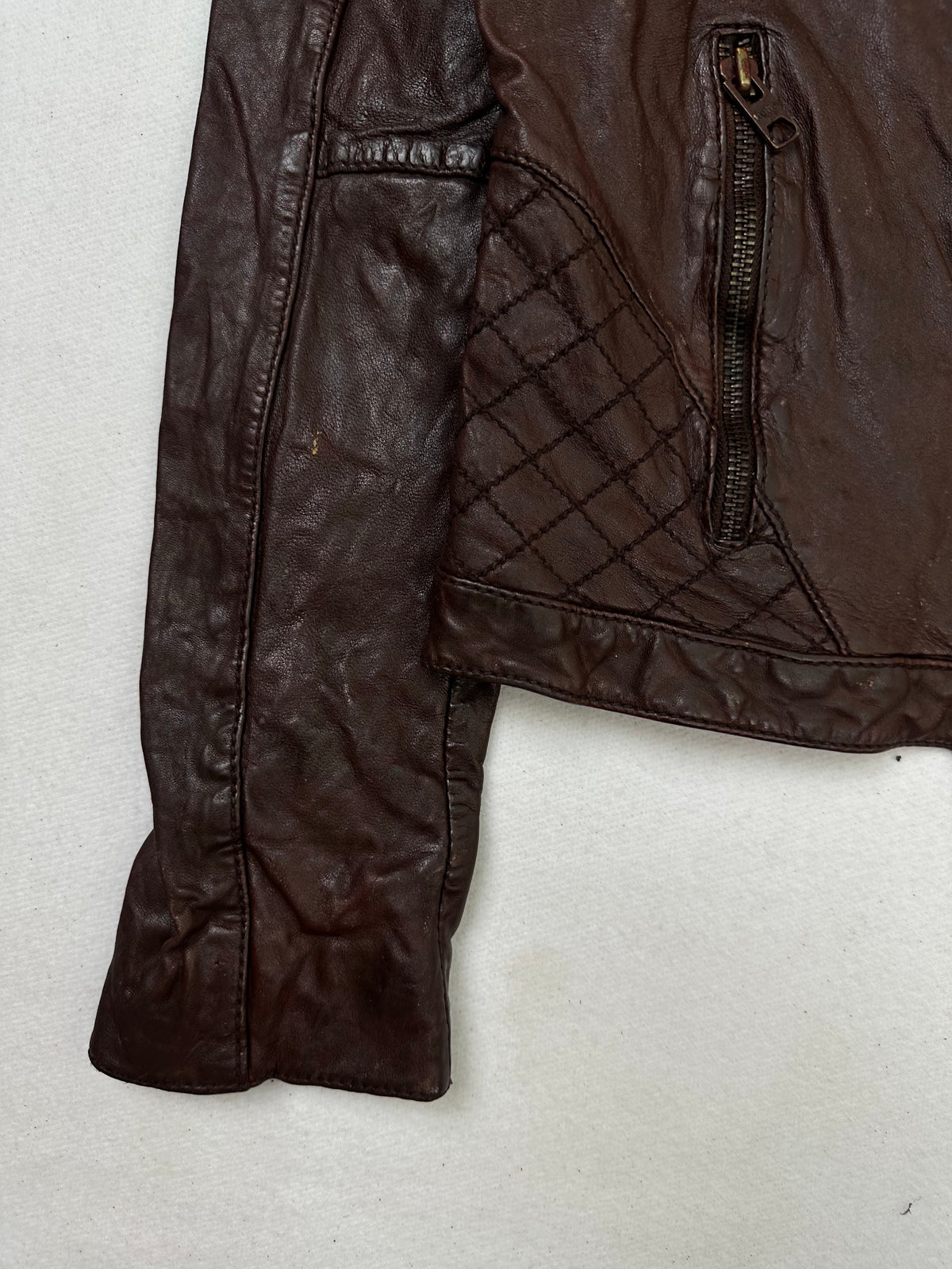 Close detail of the pockets and cuff on the size S burgundy leather vintage jacket