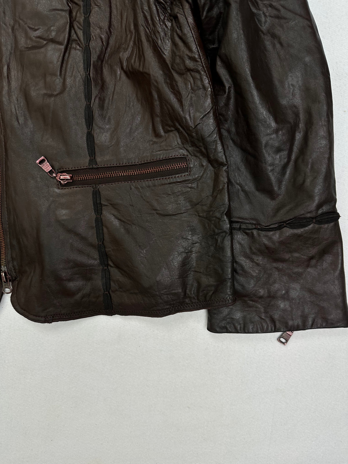 Side pocket and hem of the size S brown leather cafe racer jacket, up close