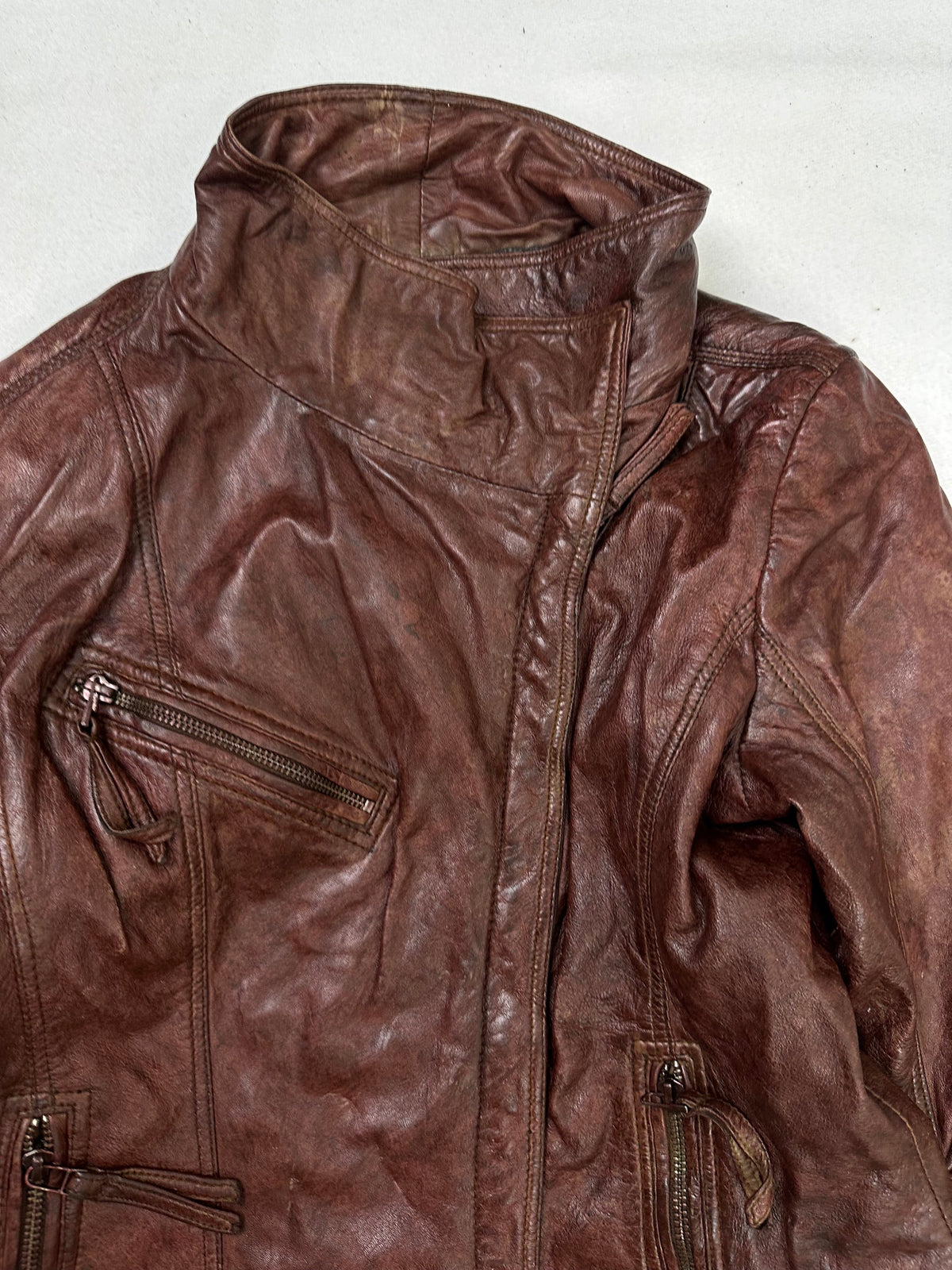 Collar and zip of the size S burgundy leather biker jacket, up close