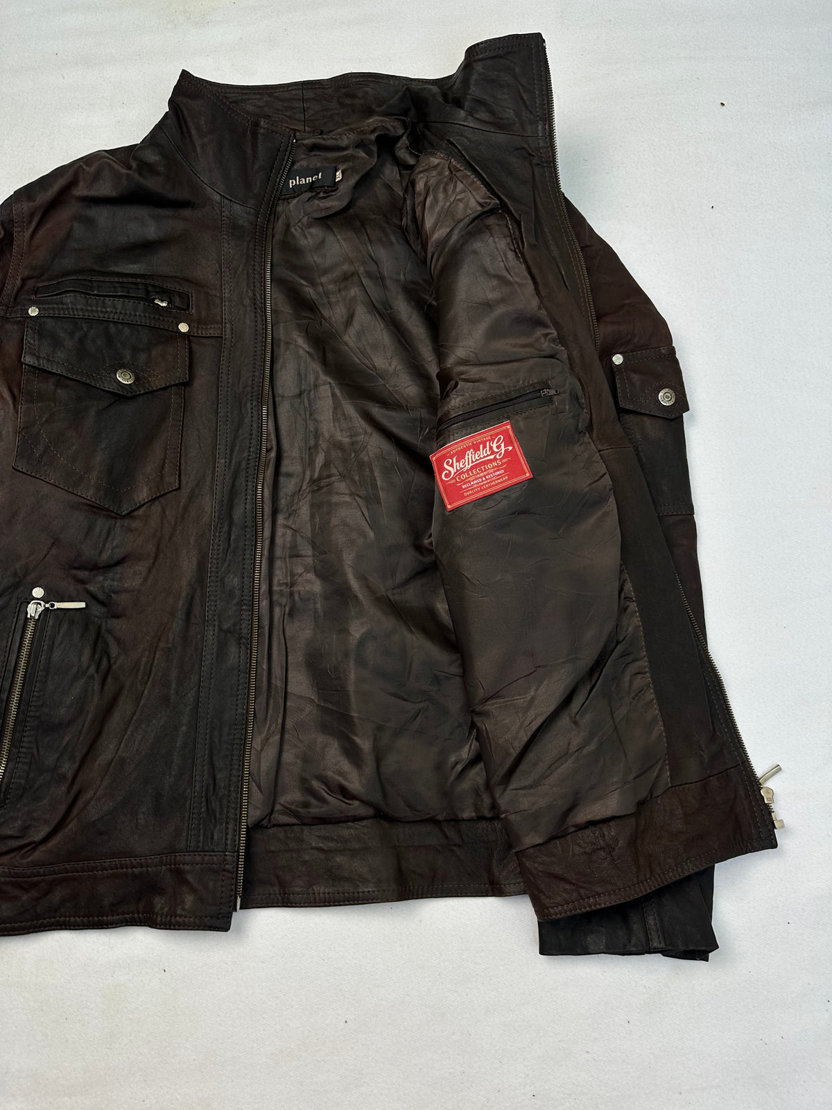 The size L brown leather cafe racer jacket opened to show the lining