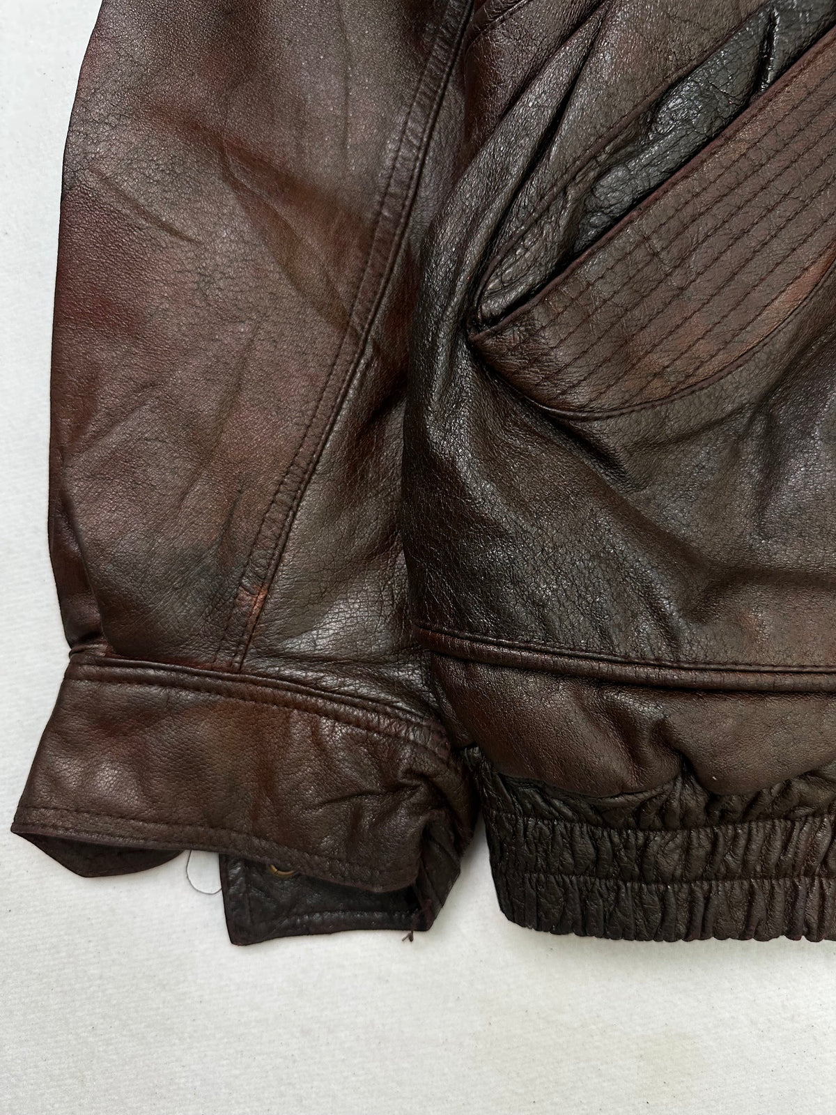 Close detail of the pockets and cuff on the size L burgundy leather flight jacket