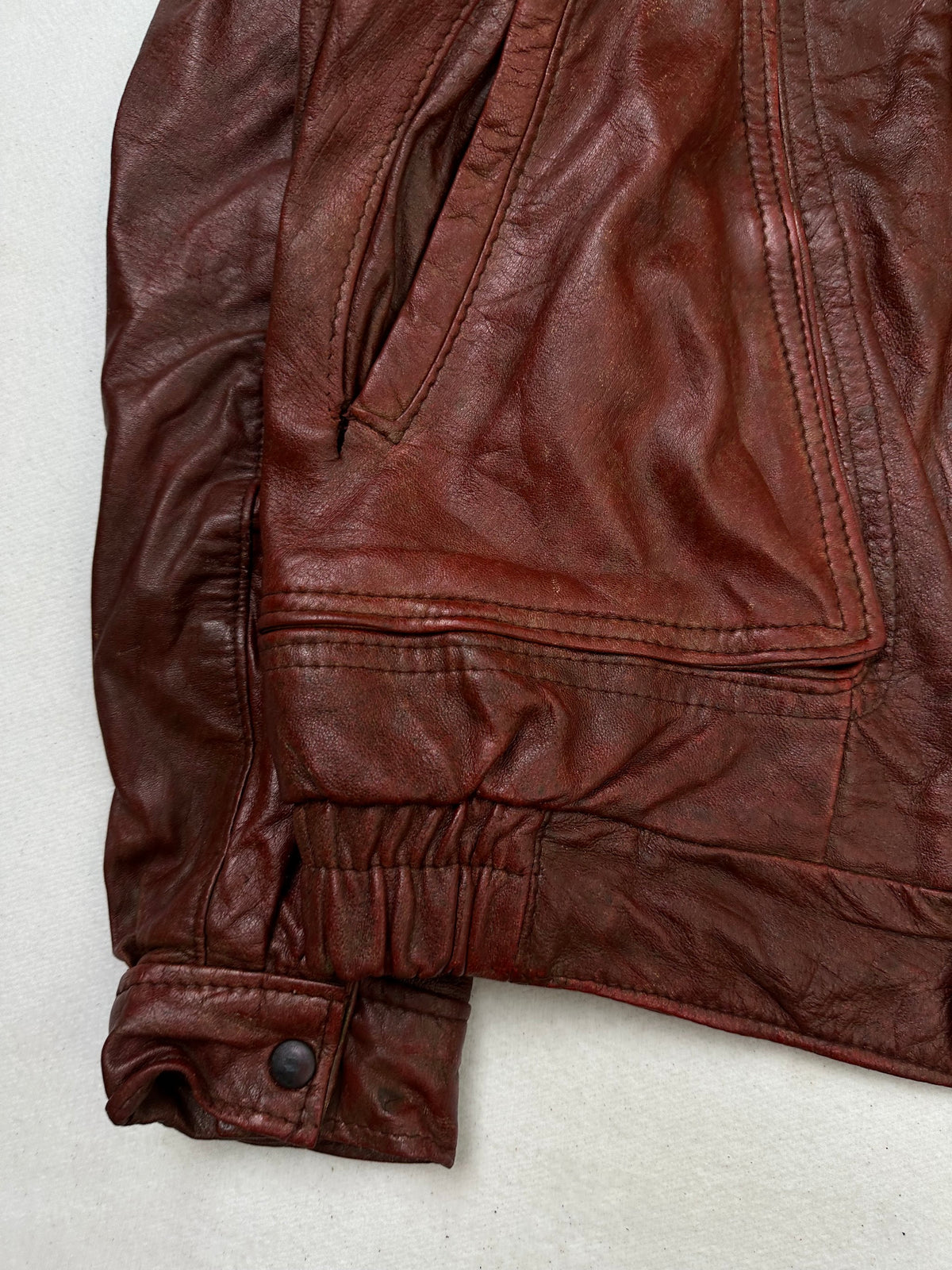 Close detail of the pockets and cuff on the size L burgundy leather flight jacket