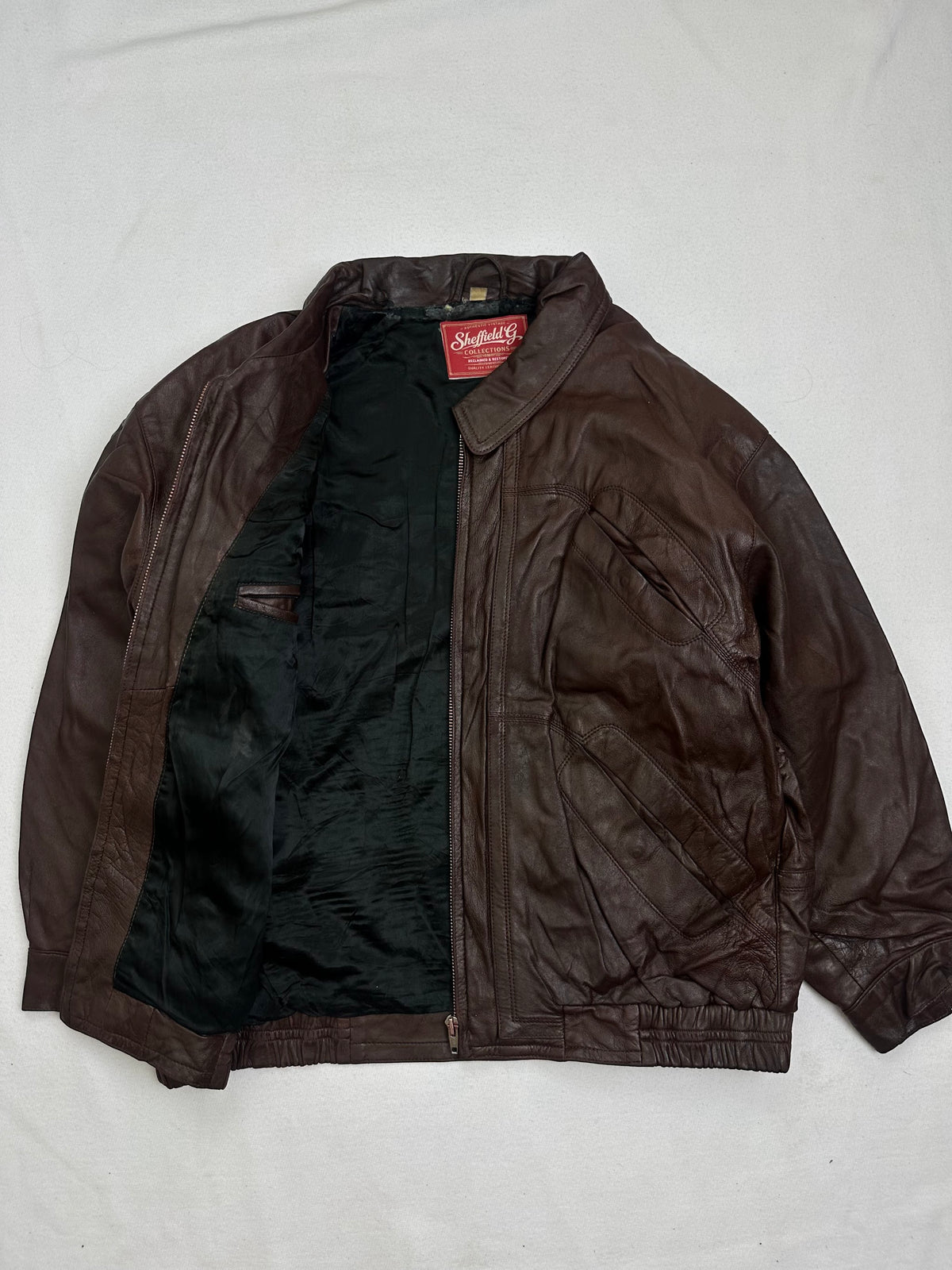 The size L burgundy leather flight jacket opened to show the lining