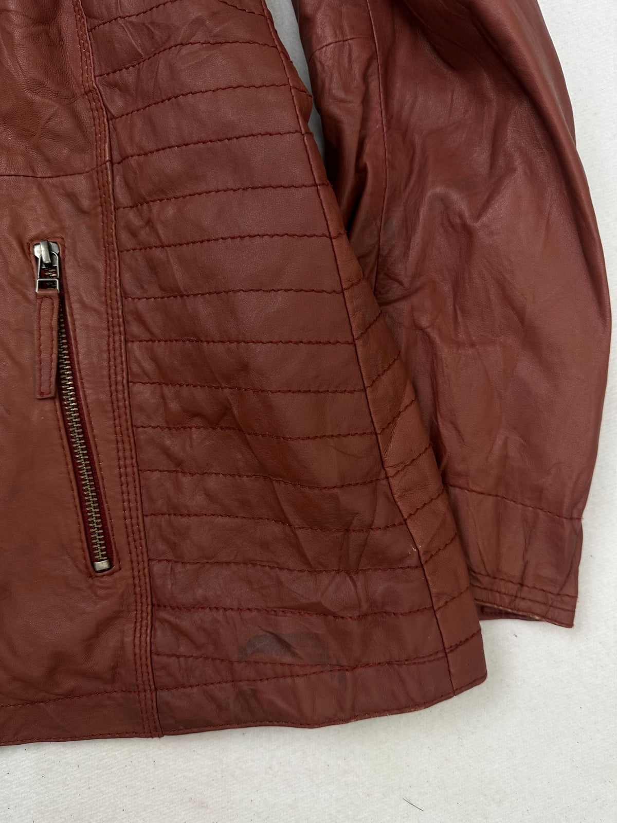 Side pocket and hem of the size XL burgundy leather vintage jacket, up close