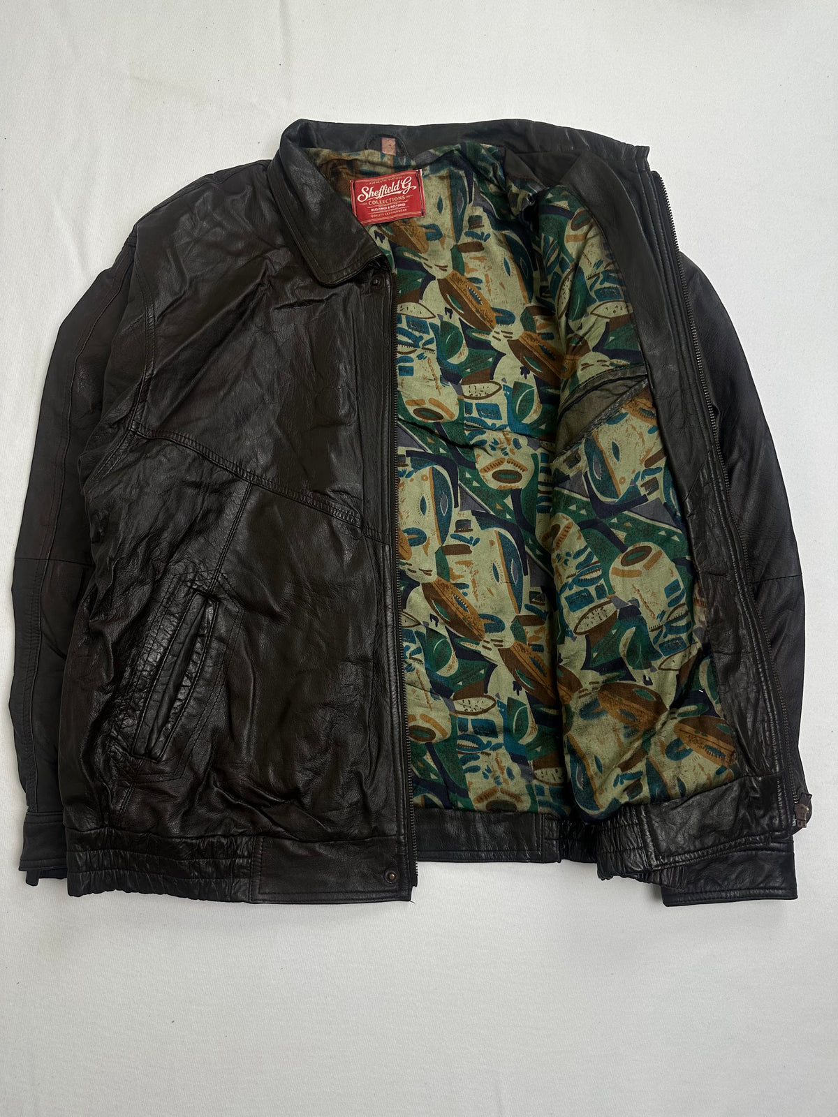 Cream and green printed lining shown with the brown harrington held open