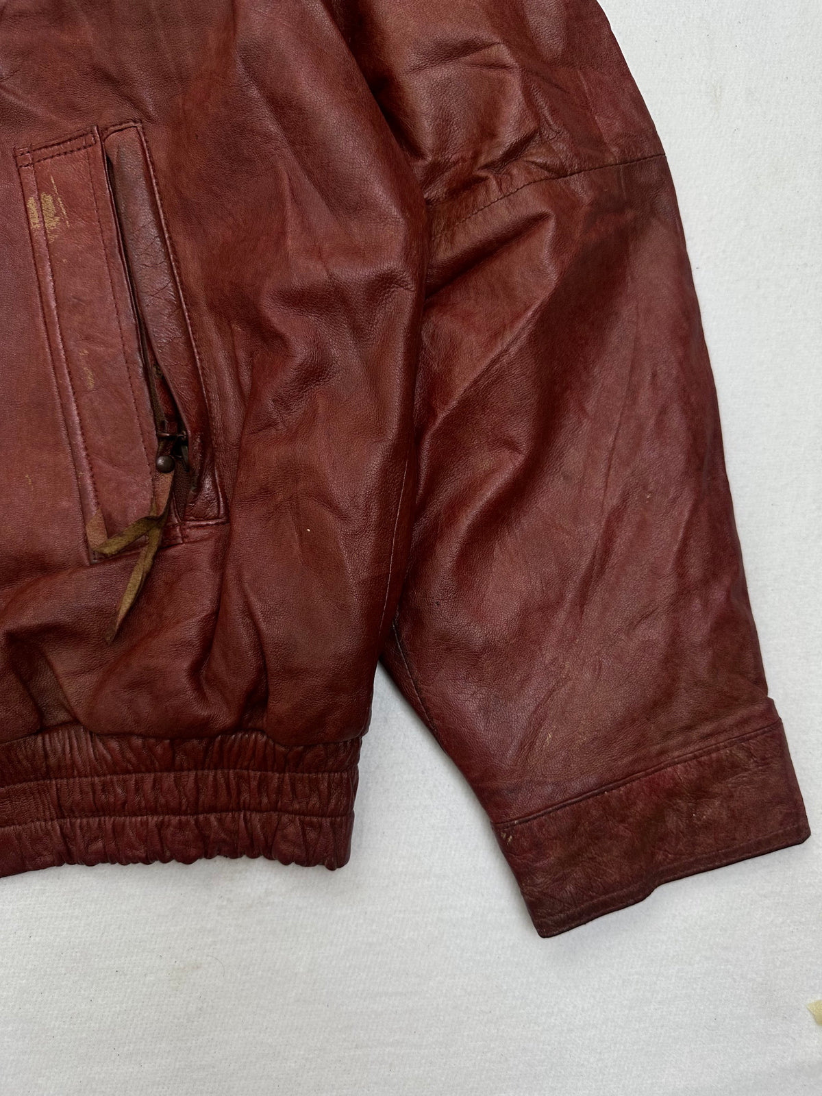 Side pocket and hem of the size XL burgundy leather harrington jacket, up close