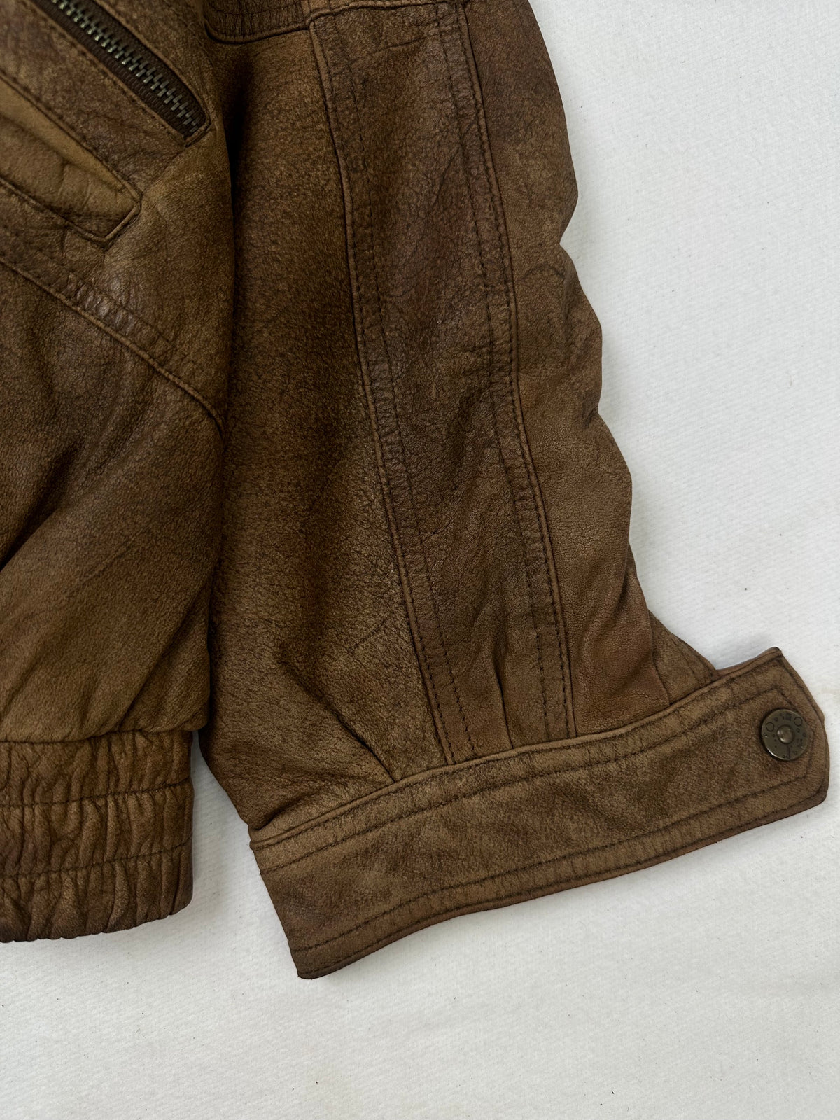 Side pocket and hem of the size XL brown leather flight jacket, up close