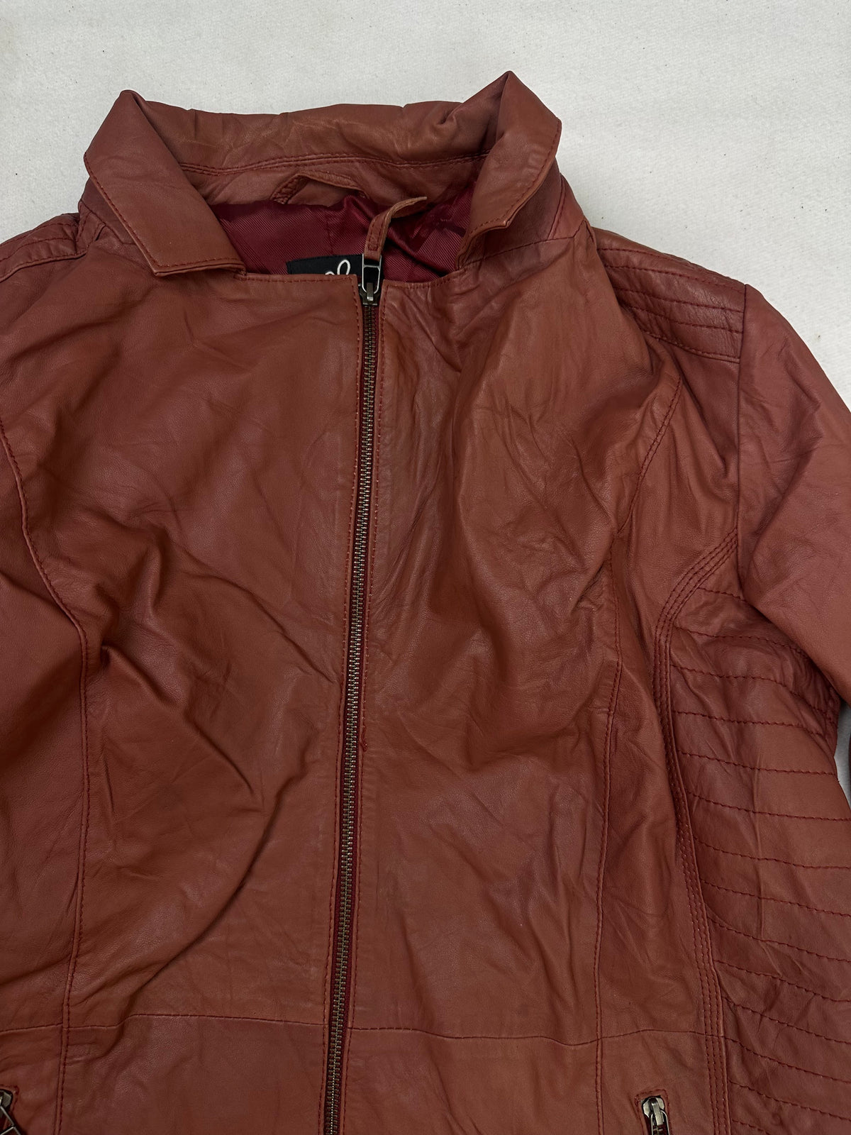 Collar and zip of the size XL burgundy leather vintage jacket, up close