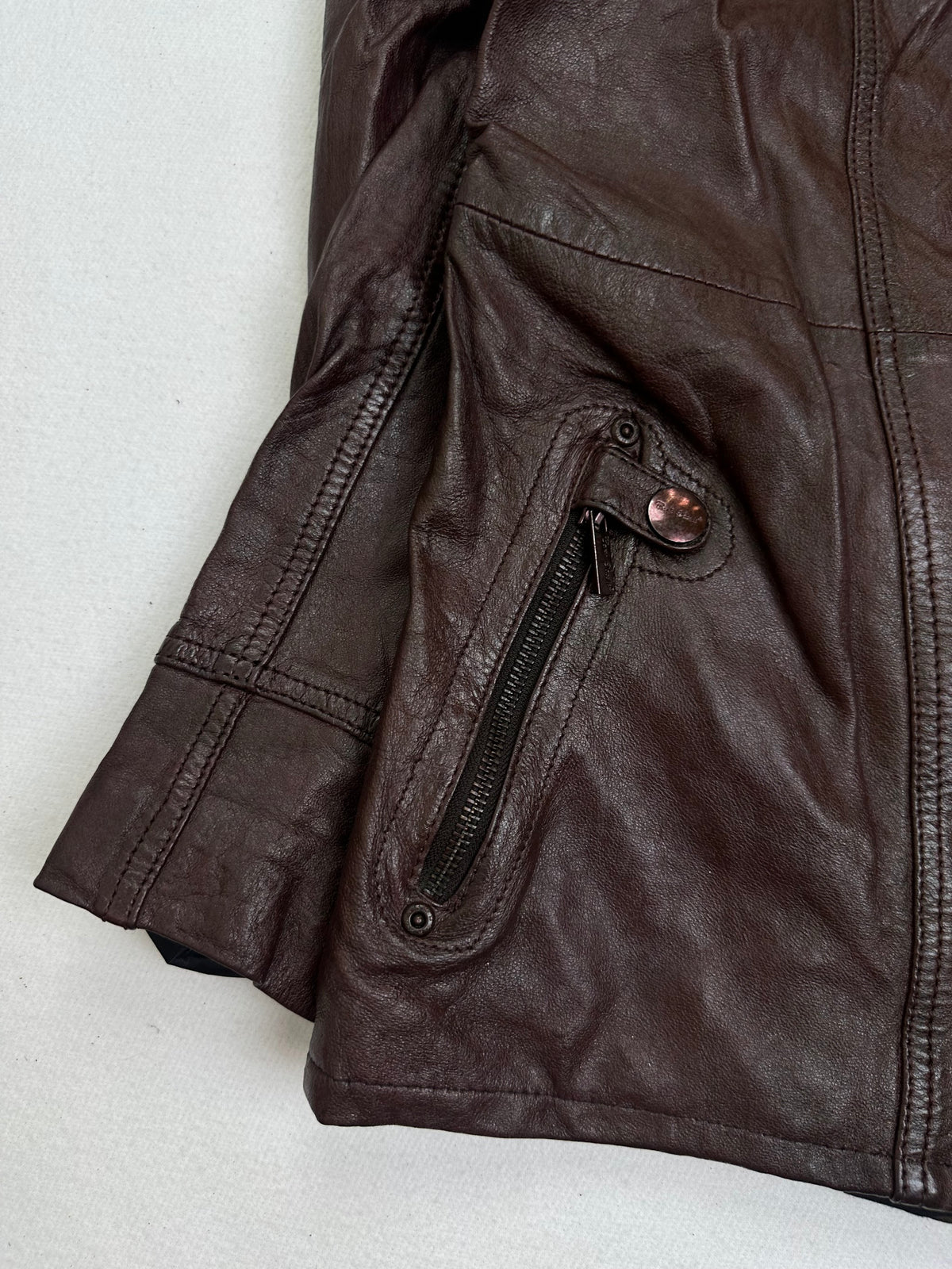 Close detail of the pockets and cuff on the size M burgundy leather biker jacket