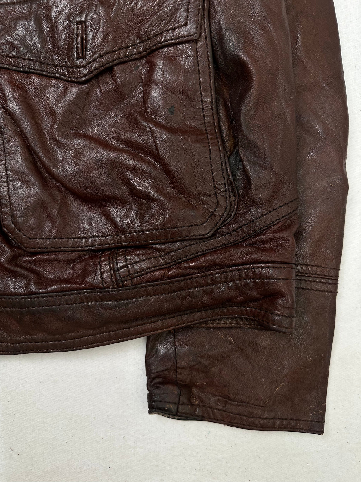 Side pocket and hem of the size L burgundy leather field jacket, up close