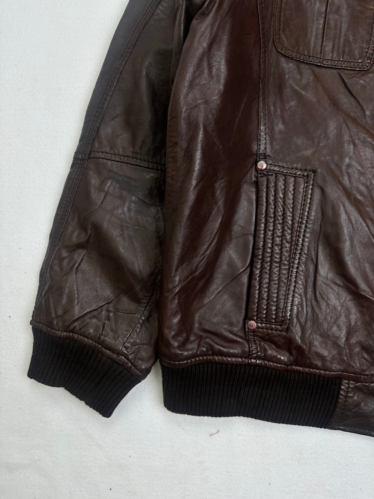Close detail of the pockets and cuff on the size L burgundy leather bomber jacket