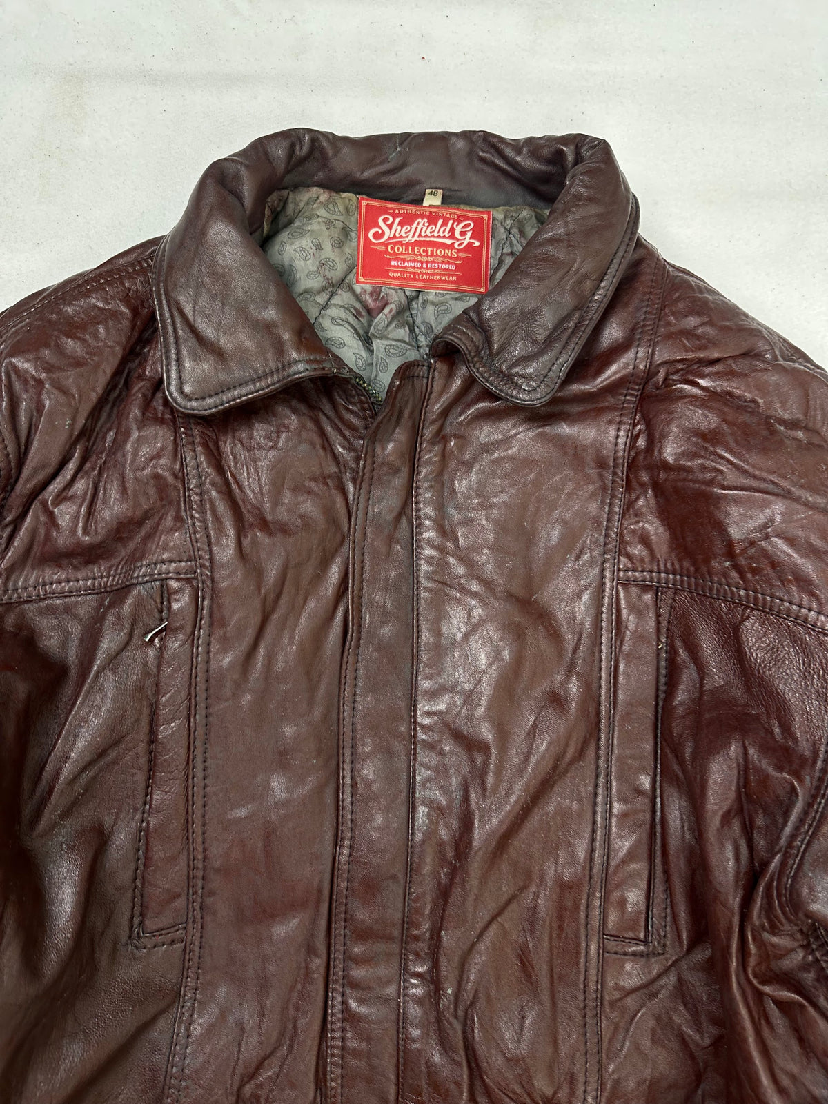 Collar and zip of the size M burgundy leather vintage jacket, up close