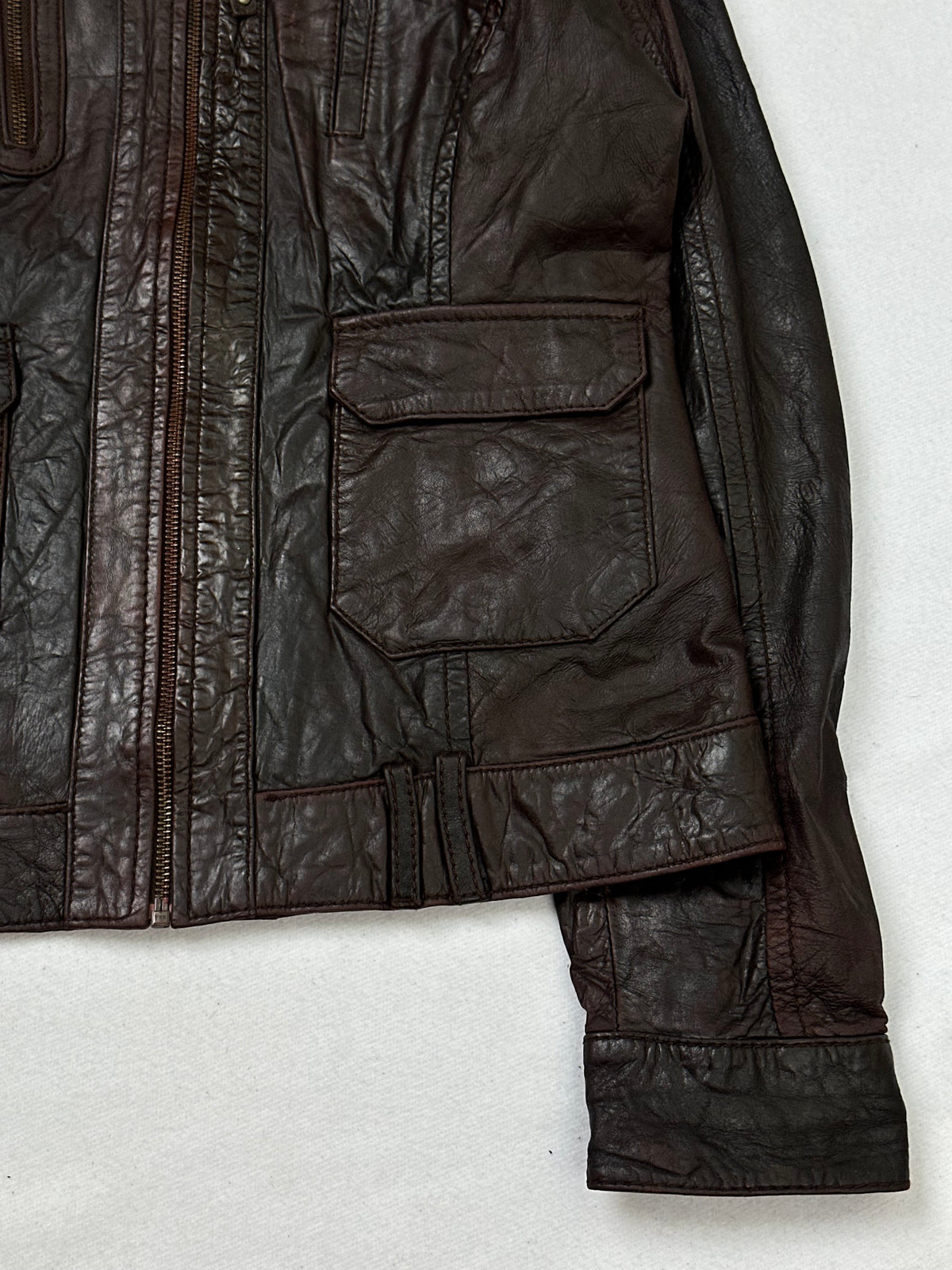 Side pocket and hem of the size XS brown leather cafe racer jacket, up close