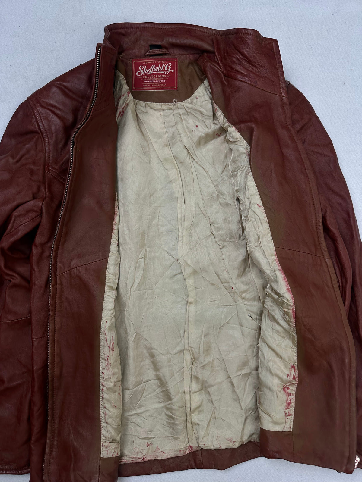 The size S burgundy leather cafe racer jacket opened to show the lining