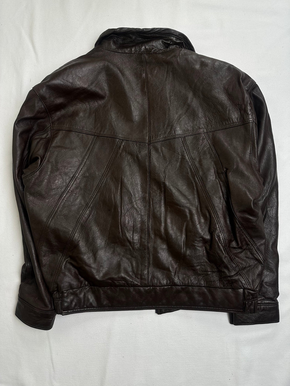 Pointed shirt collar pressing shut above the leather placket