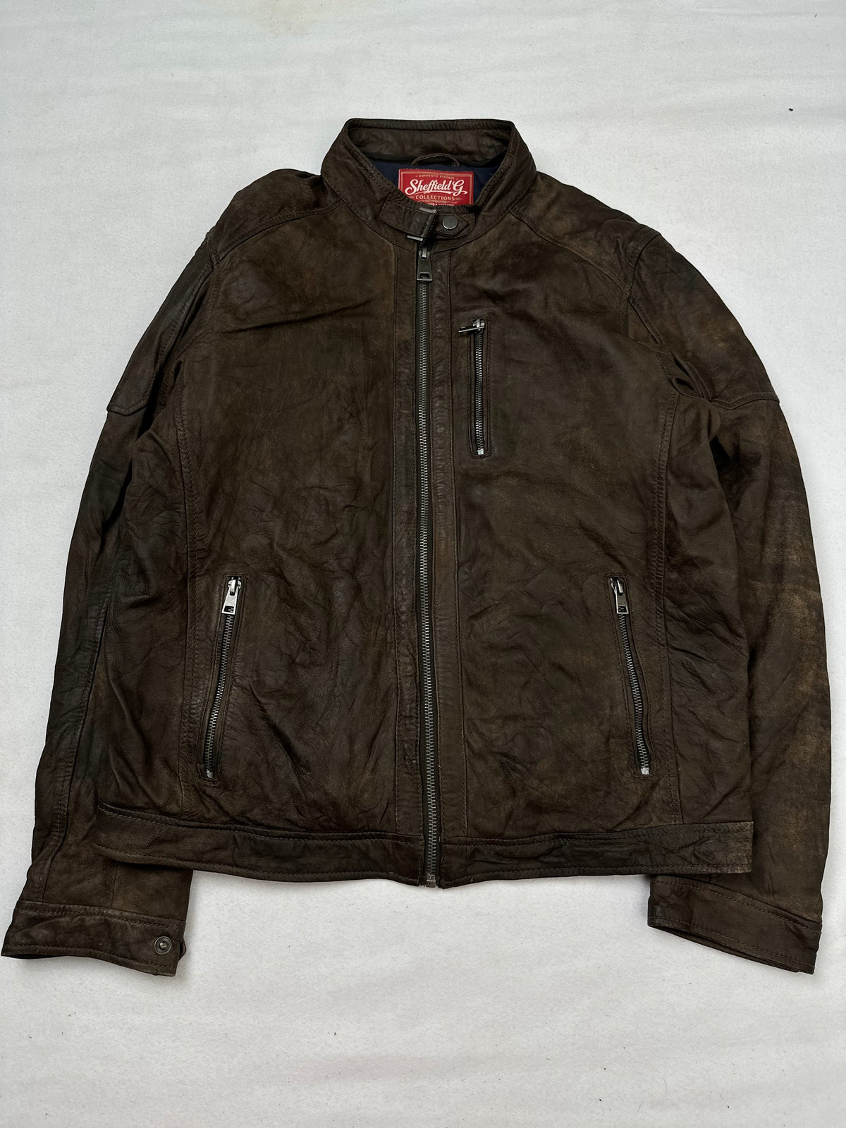 Front of the size M brown leather cafe racer jacket, laid flat and unedited