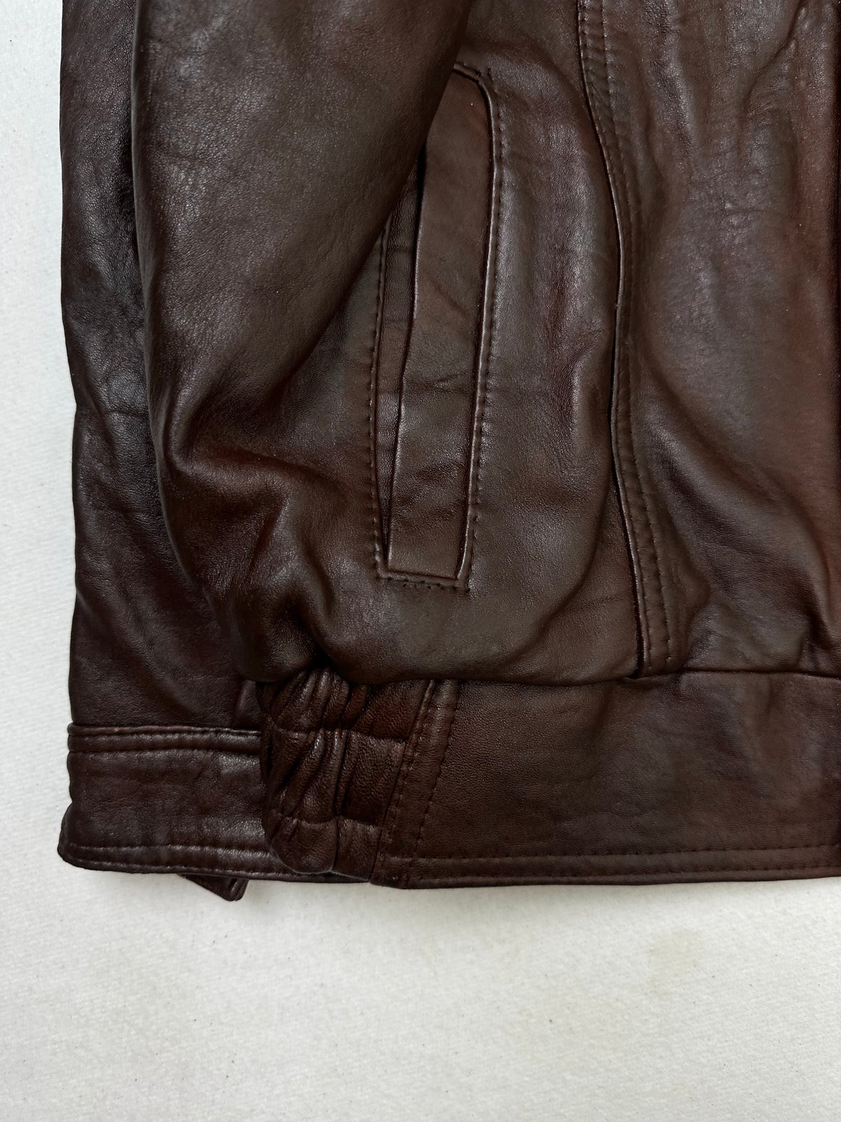 Close detail of the pockets and cuff on the size L burgundy leather flight jacket
