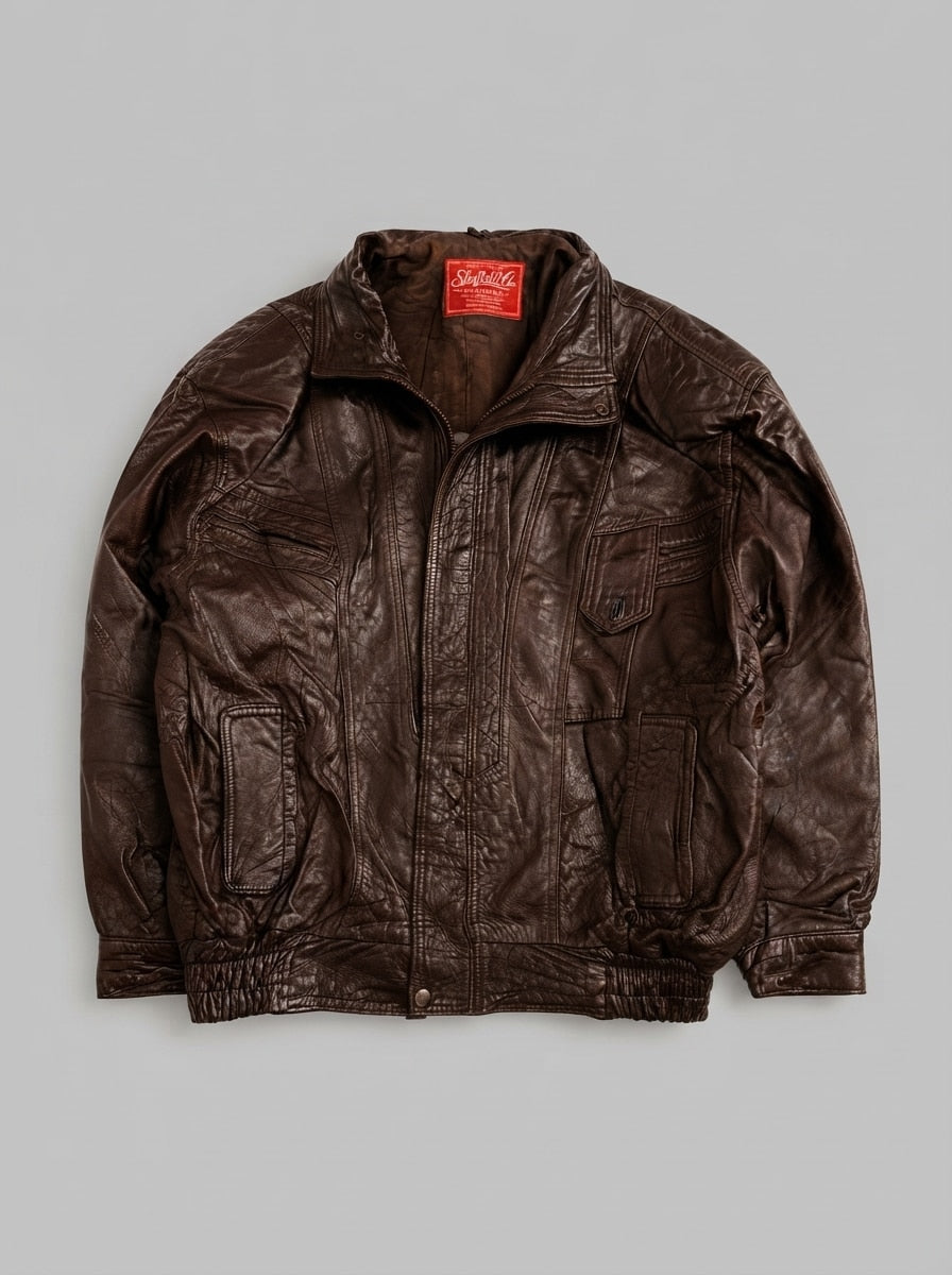 Brown leather harrington jacket laid flat, pointed collar with throat tab, centre zip and shirred leather waistband