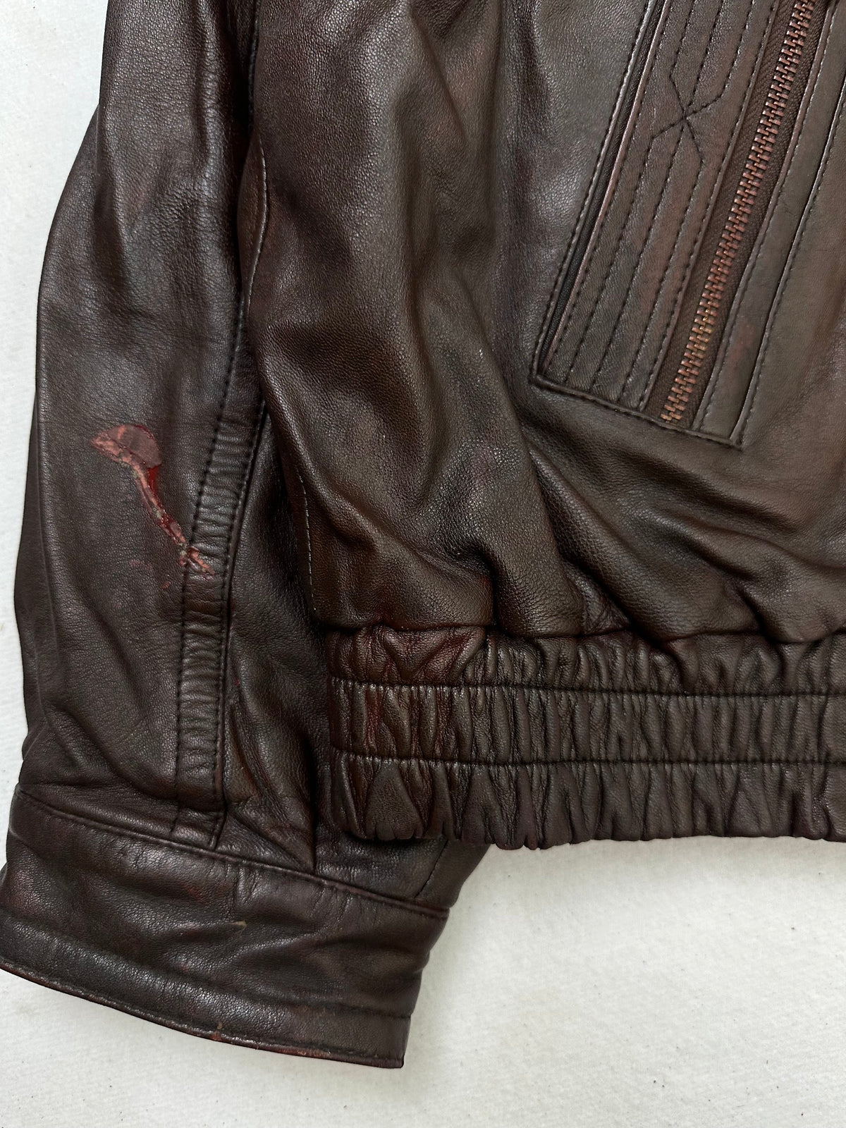 A small mark on the size L burgundy leather flight jacket, shown up close