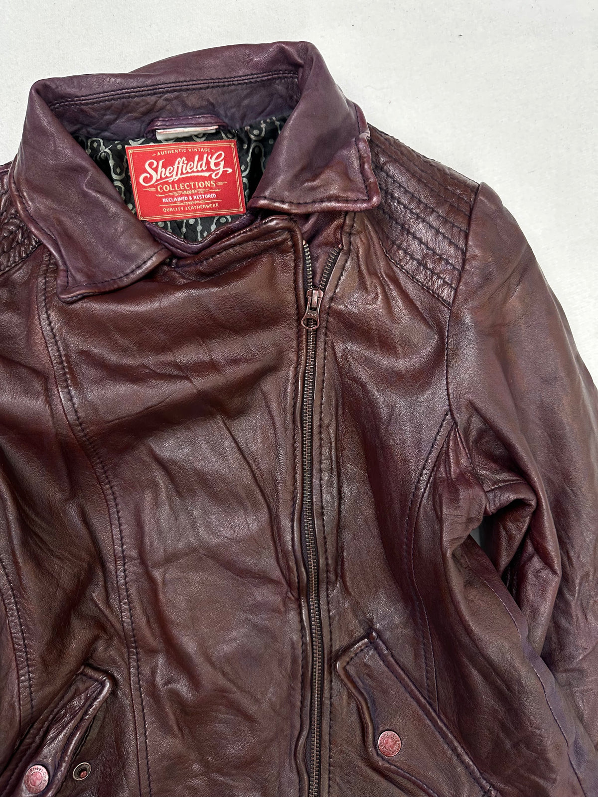 Collar and zip of the size S burgundy leather biker jacket, up close