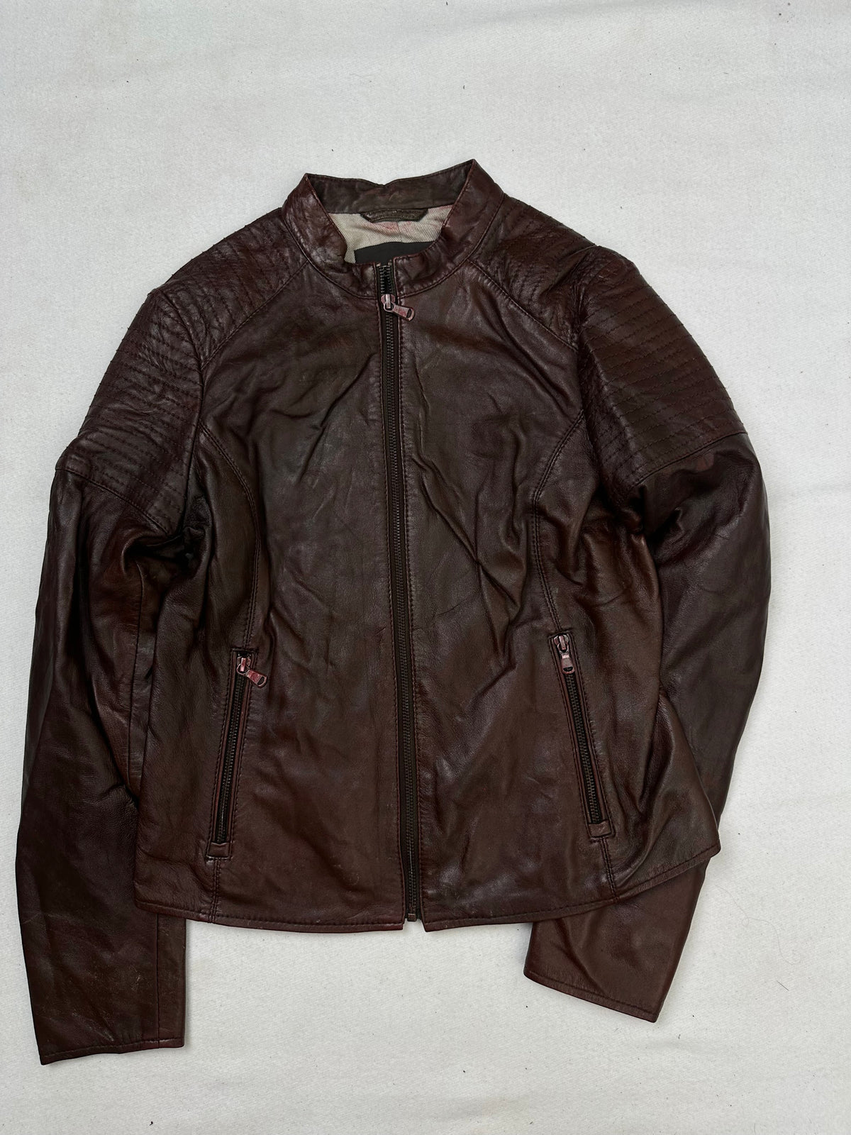 Front of the size XS burgundy leather cafe racer jacket, laid flat and unedited