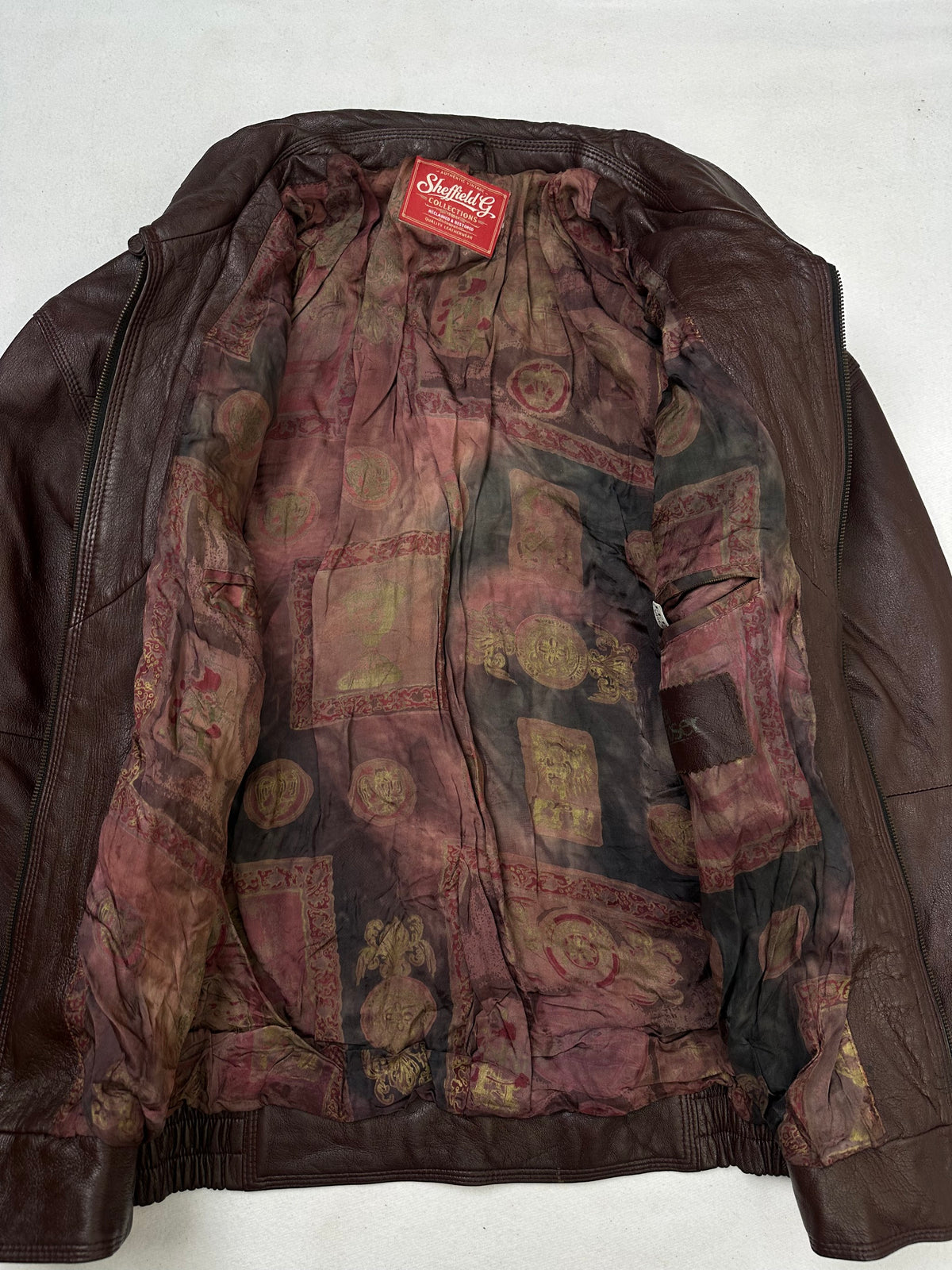 The size L burgundy leather harrington jacket opened to show the lining