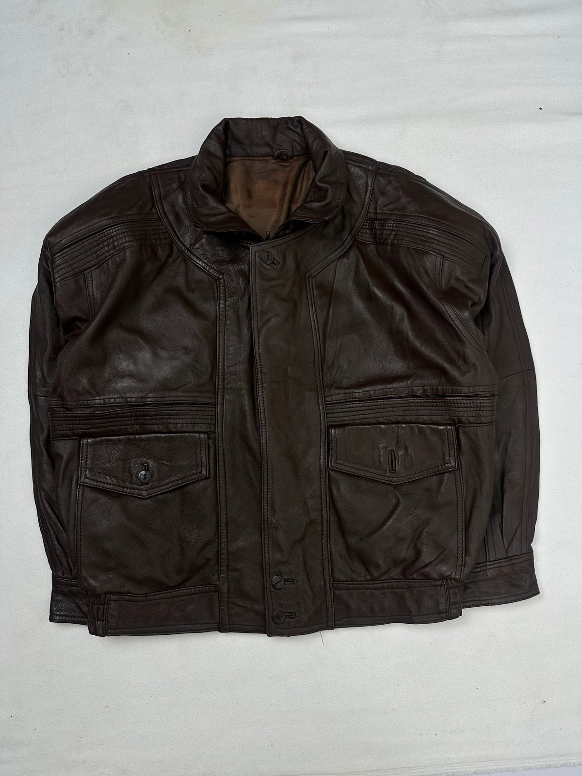Front of the size L brown leather flight jacket, laid flat and unedited
