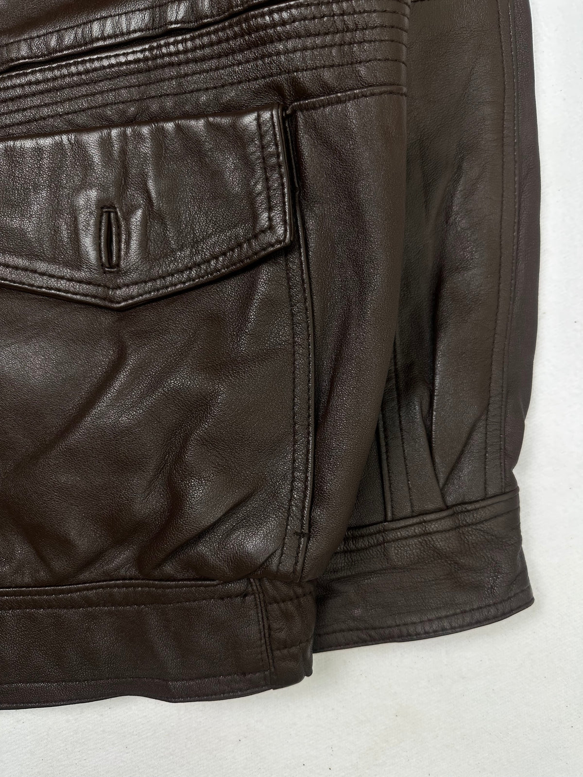 Side pocket and hem of the size L brown leather flight jacket, up close