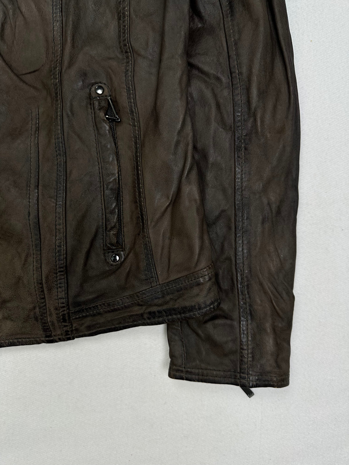 Side pocket and hem of the size S brown leather cafe racer jacket, up close