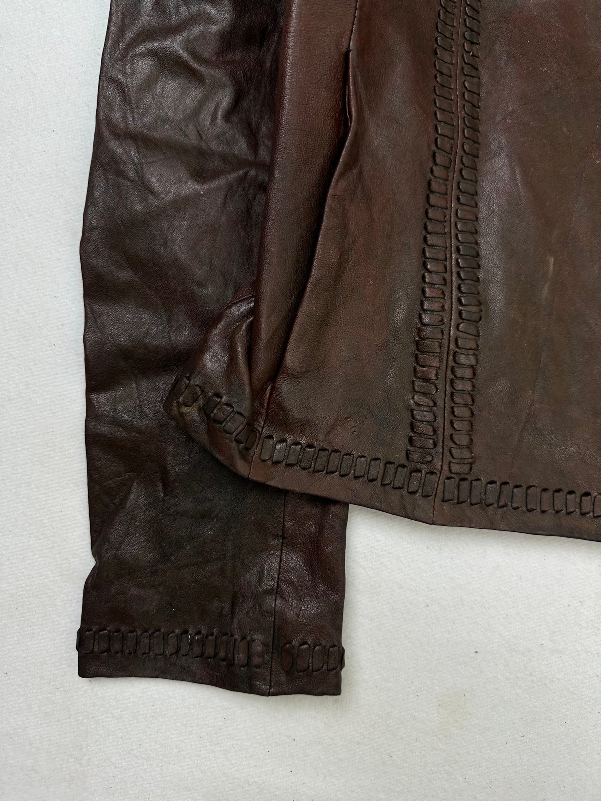 Close detail of the pockets and cuff on the size S burgundy leather vintage jacket