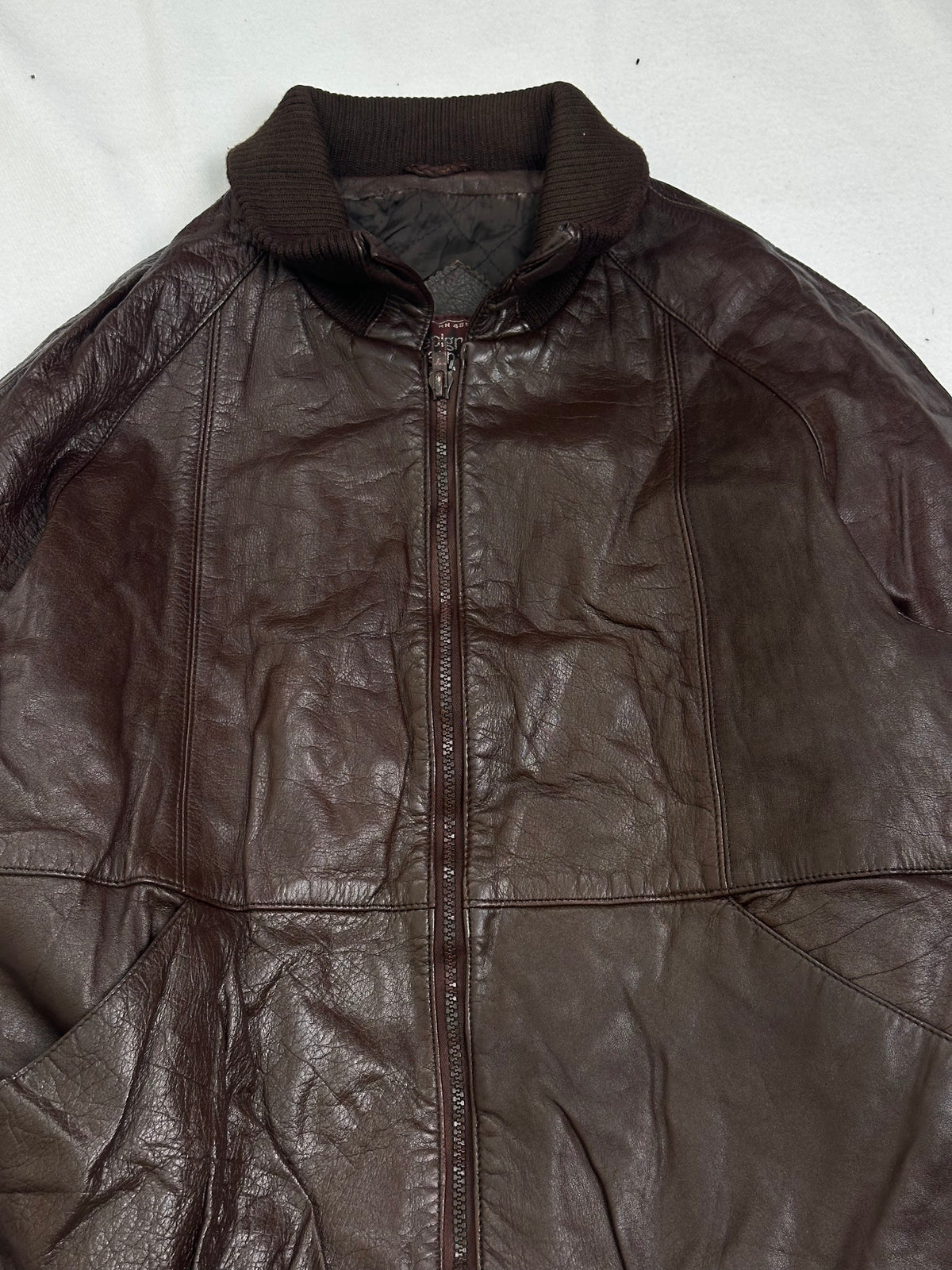 Slanted welt pocket in the waist yoke seam beside the rib hem