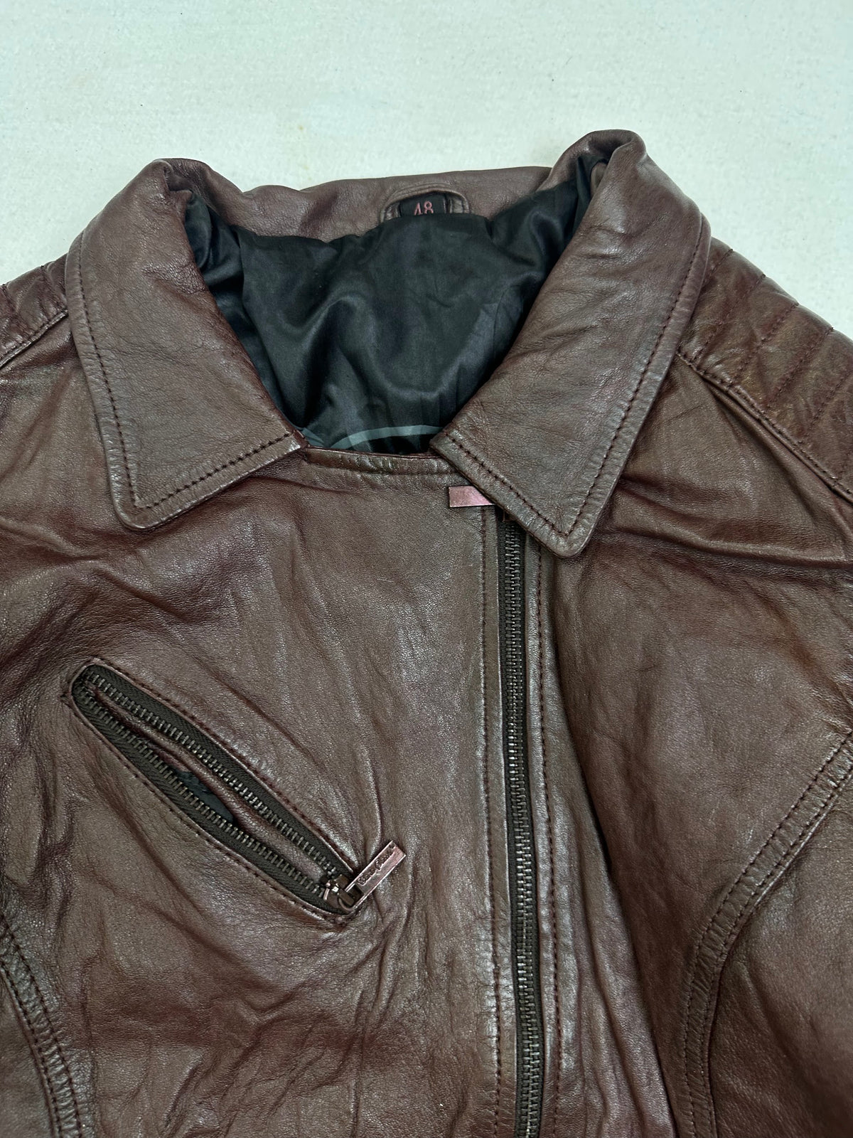 Collar and zip of the size M burgundy leather biker jacket, up close