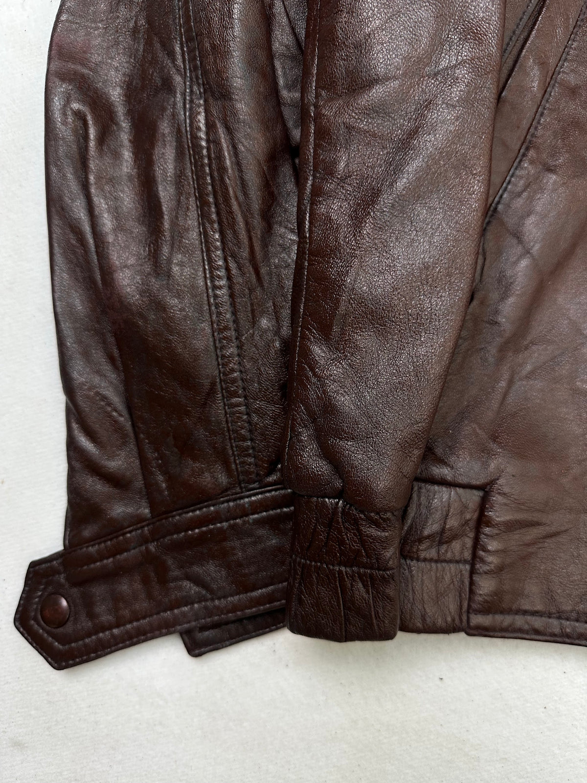 Close detail of the pockets and cuff on the size L burgundy leather biker jacket