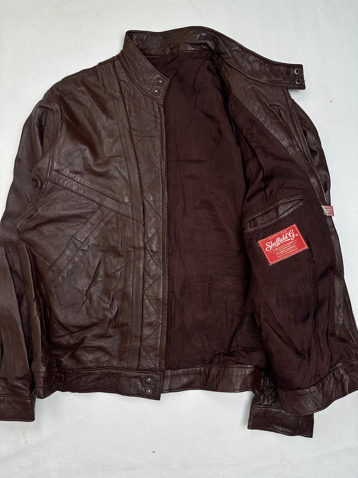 The size L burgundy leather vintage jacket opened to show the lining