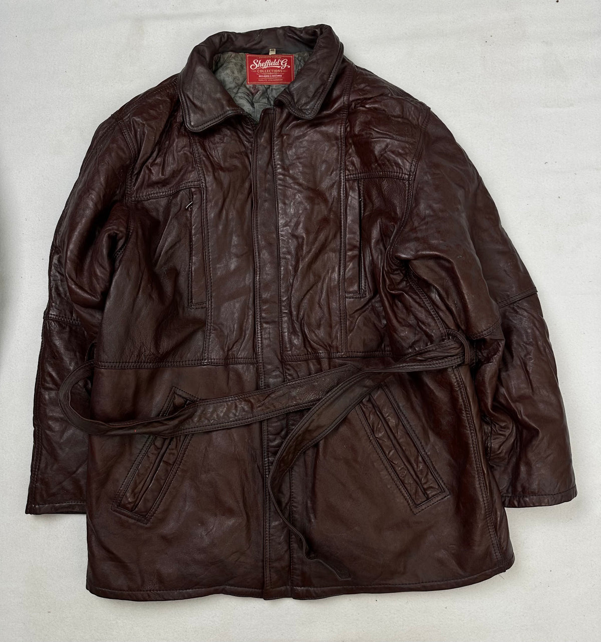 Front of the size M burgundy leather vintage jacket, laid flat and unedited
