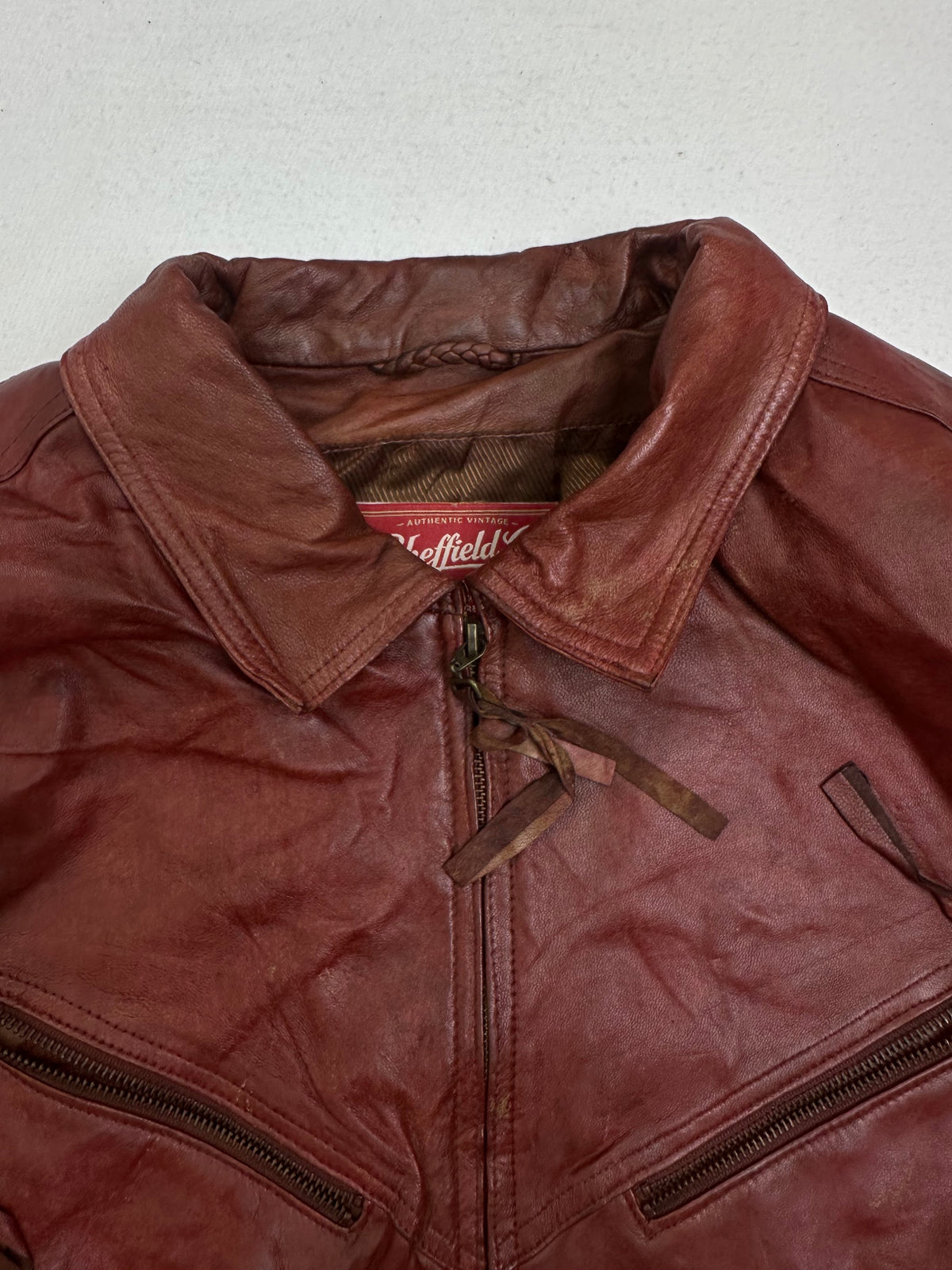 Collar and zip of the size XL burgundy leather harrington jacket, up close